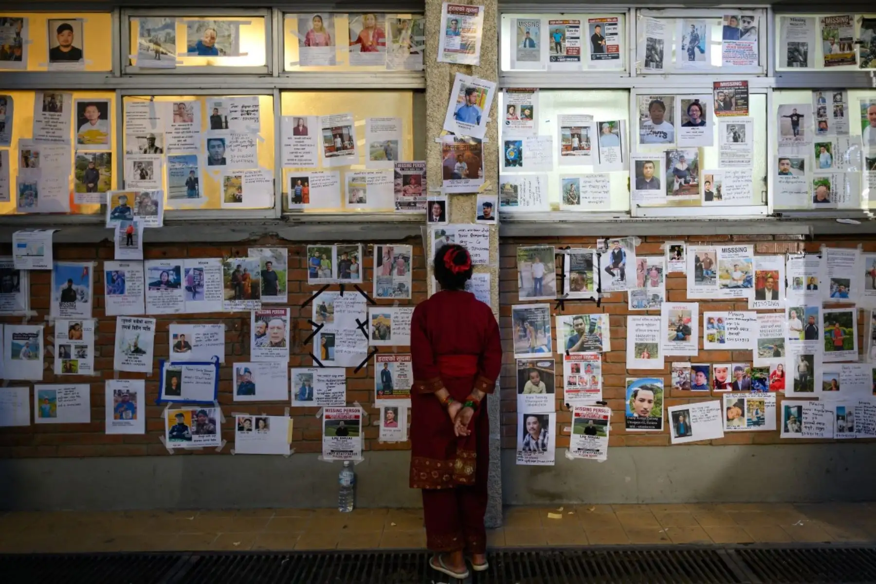 Una mujer observa fotografías de personas desaparecidas tras las inundaciones repentinas, en el Hospital Universitario Tribhuvan de Katmandú. Foto: AFP