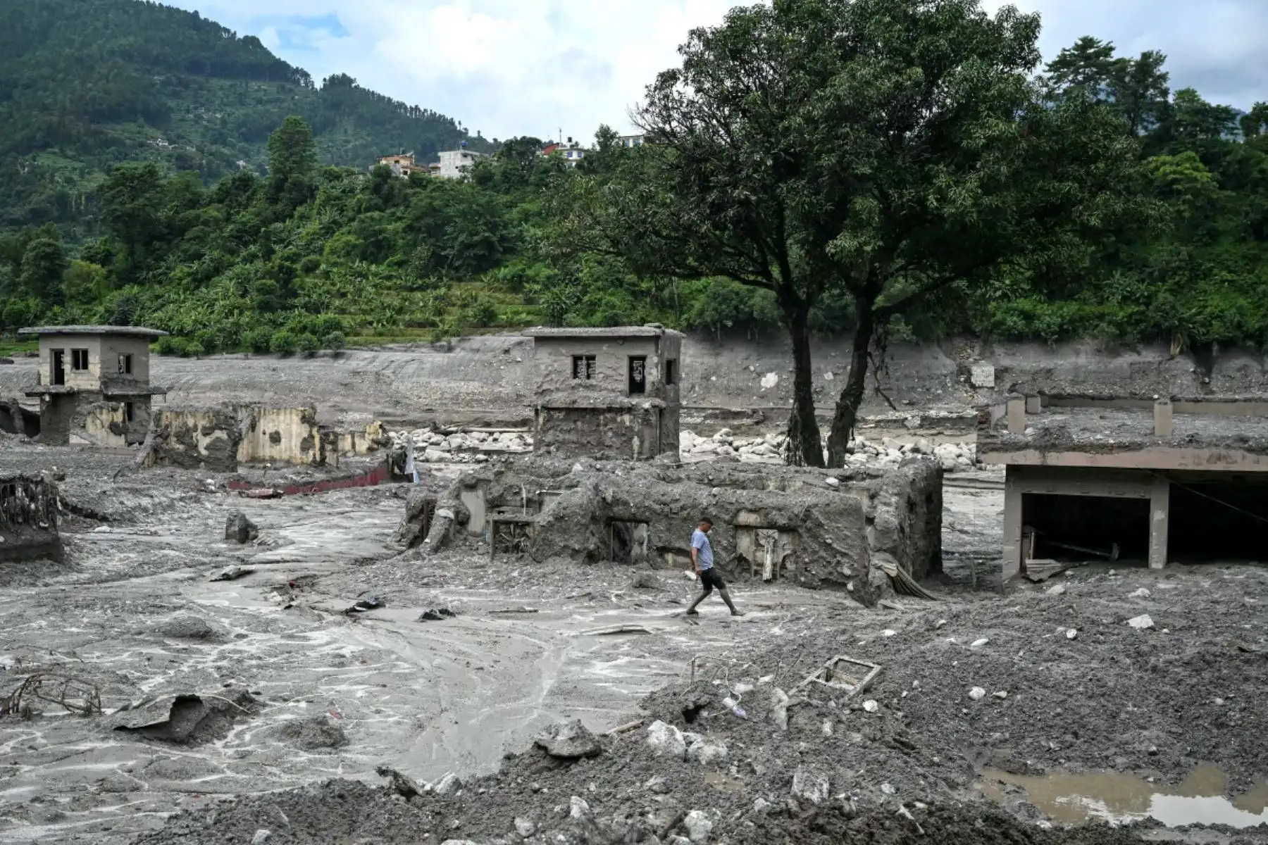 Un hombre camina por el lodo tras las repentinas inundaciones en Trishuli, en el distrito de Nuwakot, Nepal. Foto: AFP