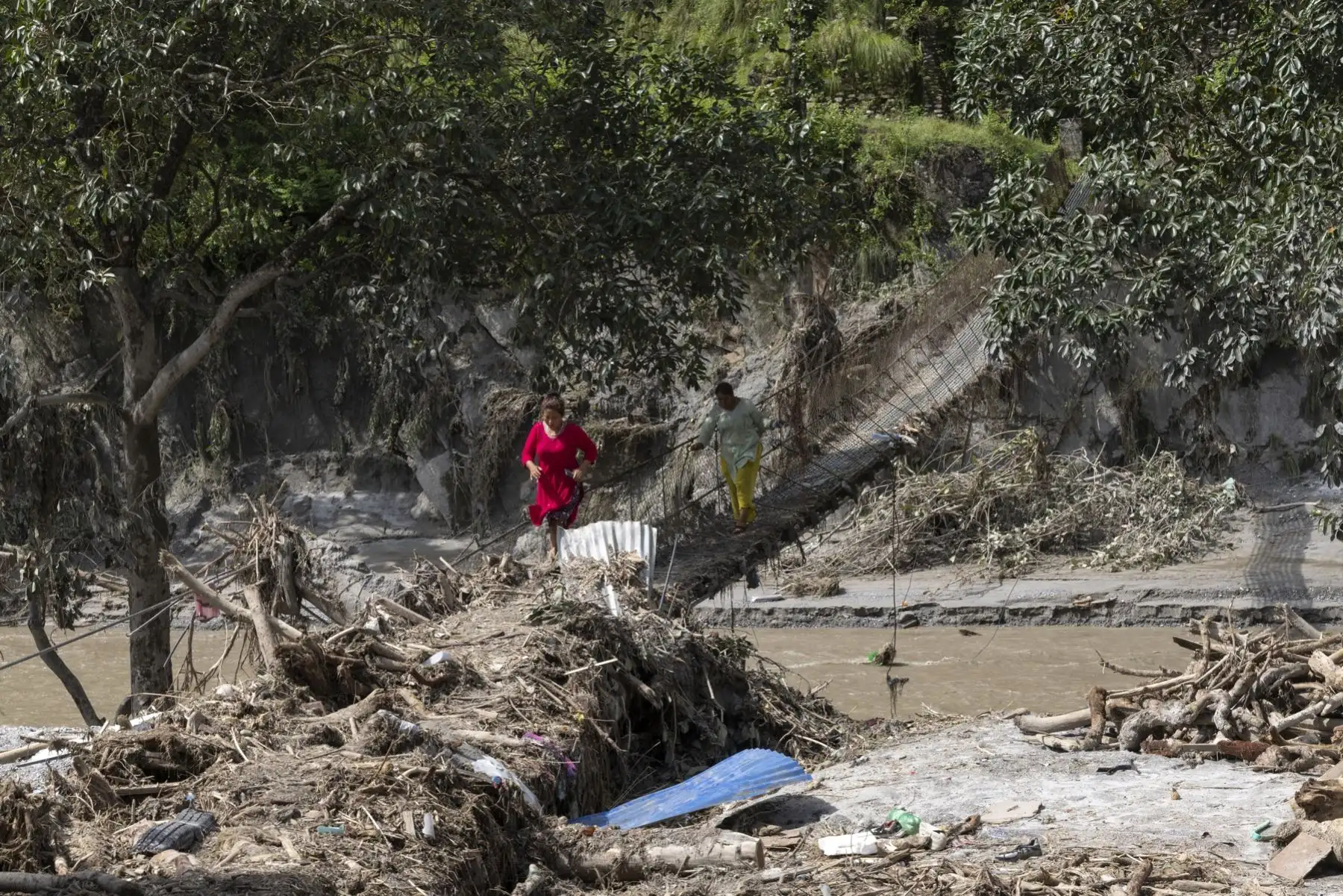 Una persona cruza un puente colgante dañado tras las inundaciones repentinas a lo largo de las orillas del río Trishuli en el distrito de Dhading, Nepal. Foto: EFE