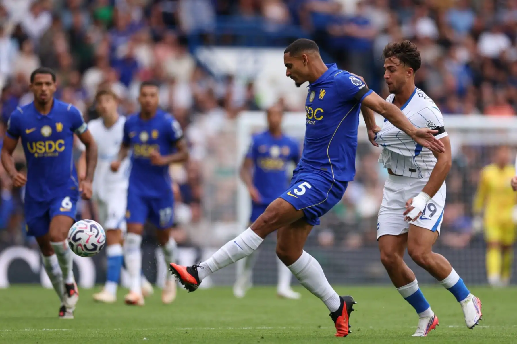 El defensa francés del Chelsea, Maxence Lacroix, es desafiado por el delantero griego del Brighton, Charalampos Kostoulas, durante el partido de la Premier League inglesa entre el Chelsea y el Brighton and Hove Albion en Stamford Bridge, Londres. Foto: ANDINA/AFP