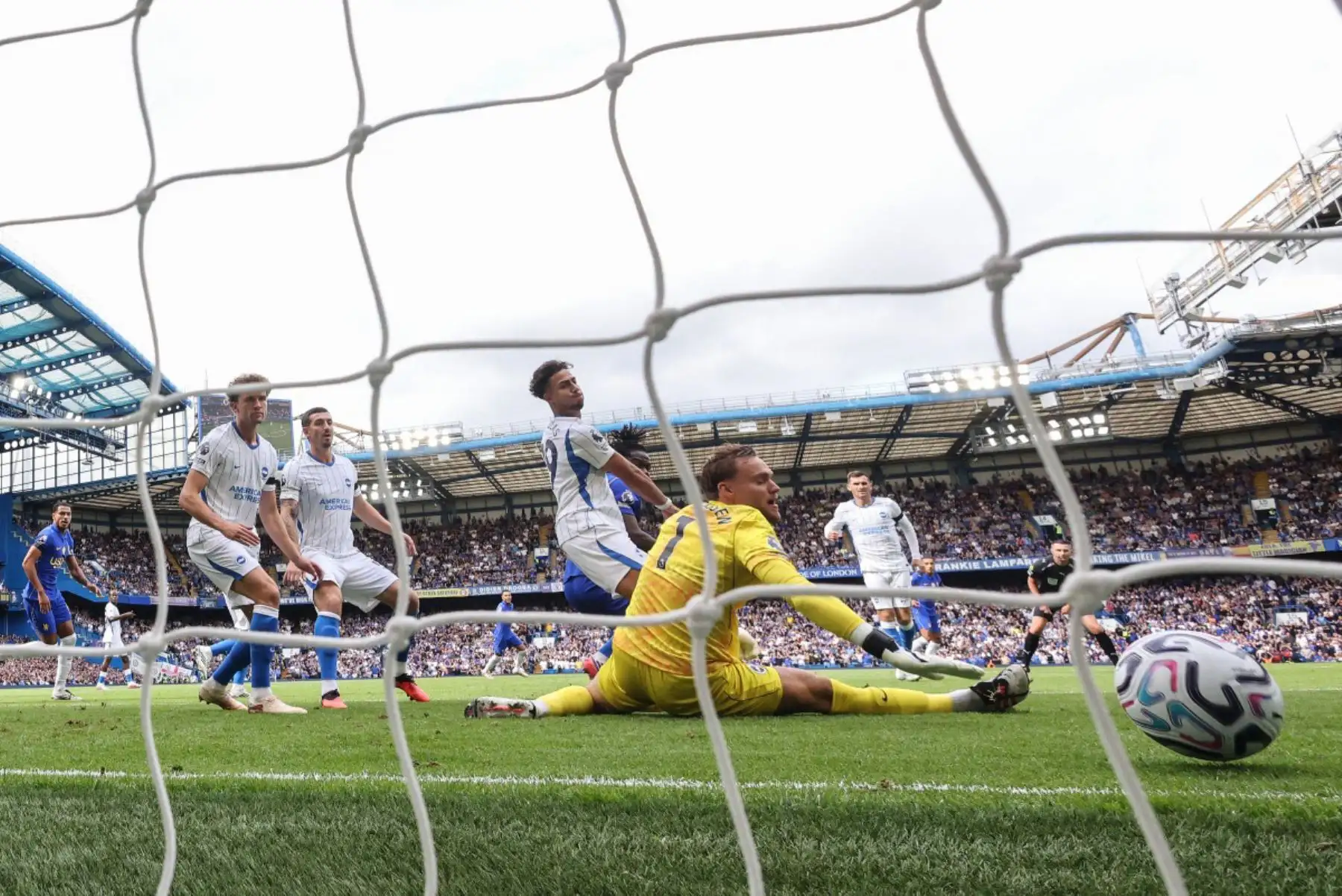 El centrocampista belga del Chelsea, Romeo Lavia, anota ante el portero holandés del Brighton, Bart Verbruggen, para marcar el primer gol de su equipo durante el partido de la Premier League inglesa entre el Chelsea y el Brighton and Hove Albion en Stamford Bridge, Londres. Foto: ANDINA/AFP
