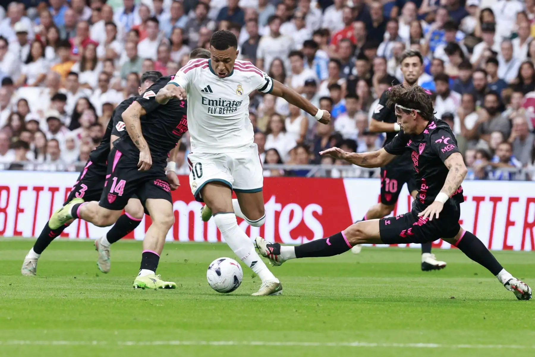 El delantero francés del Real Madrid Kylian Mbappé  rodeado de rivales durante el partido de LaLiga entre el Real Madrid y el Málaga, este domingo en el estadio Santiago Bernabéu. Foto: ANDINA/EFE