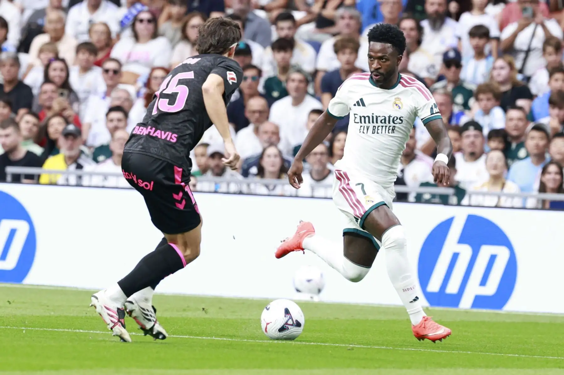 El delantero brasileño del Real Madrid Vinicius Junior controla el balón ante Ángel Recio, del Málaga, durante el partido de LaLiga entre el Real Madrid y el Málaga, este domingo en el estadio Santiago Bernabéu. Foto: ANDINA/ EFE