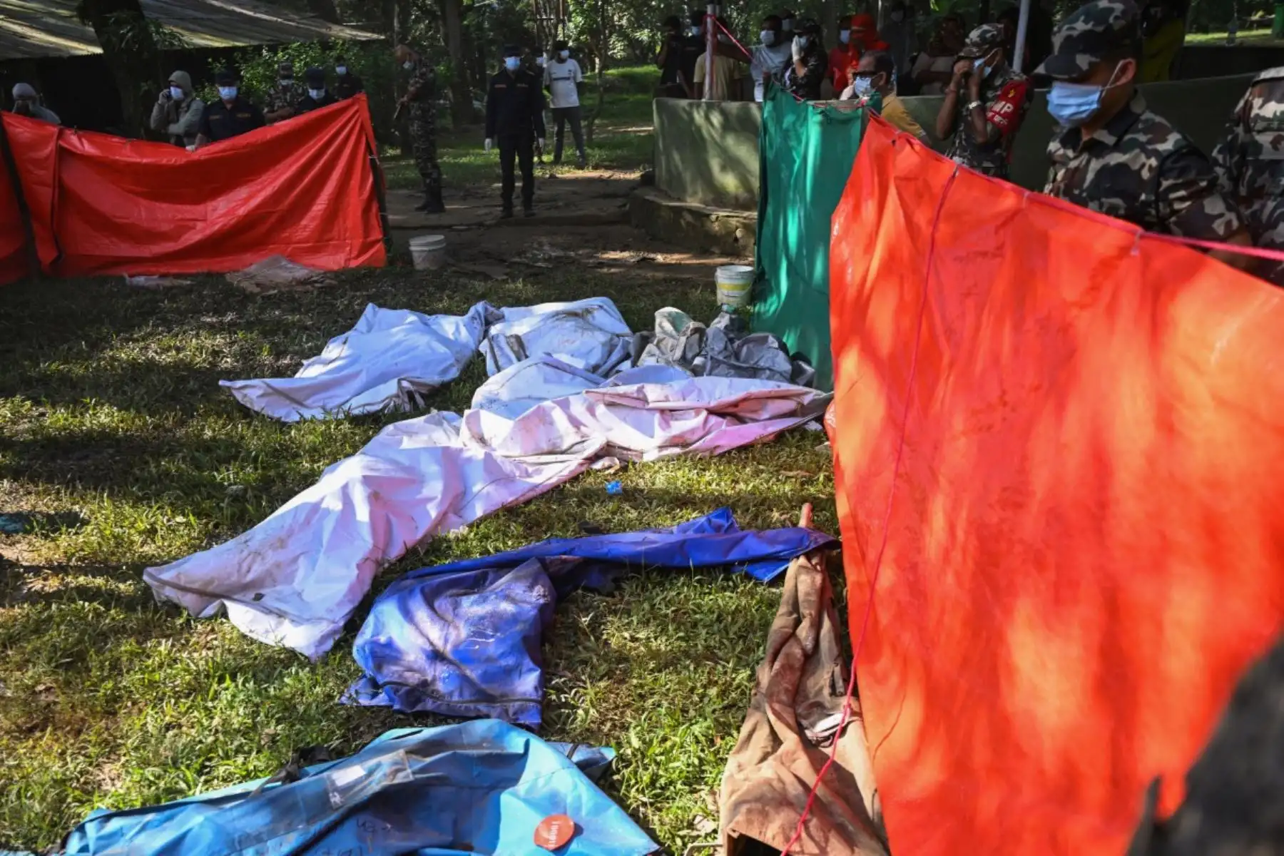 Oficiales del ejército inspeccionan los cadáveres de las víctimas de las inundaciones repentinas en el campamento de Trishuli tras las inundaciones que azotaron el distrito de Nuwakot, en Nepal, el 30 de agosto de 2026. Foto: AFP