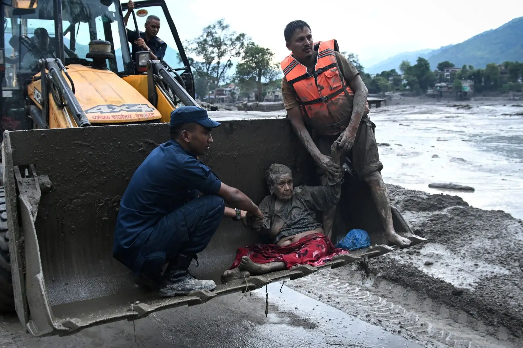 Los rescatistas utilizan una excavadora para transportar a un sobreviviente de las inundaciones, luego de un desastre de inundaciones repentinas y deslizamientos de tierra en Devghat, en el distrito de Nuwakot de Nepal, el 26 de agosto de 2026. Foto: AFP