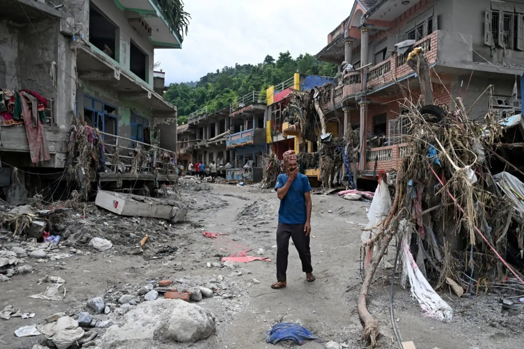 Un hombre pasa junto a casas dañadas tras unas inundaciones repentinas en Devighat, en el distrito nepalí de Nuwakot. Foto: AFP