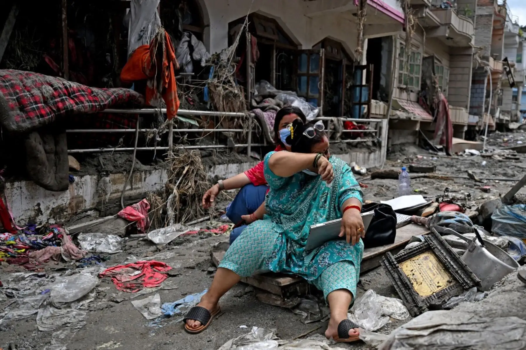 Personas rescatan sus pertenencias de sus hogares tras unas inundaciones repentinas en Devighat, en el distrito nepalí de Nuwakot. Foto: AFP