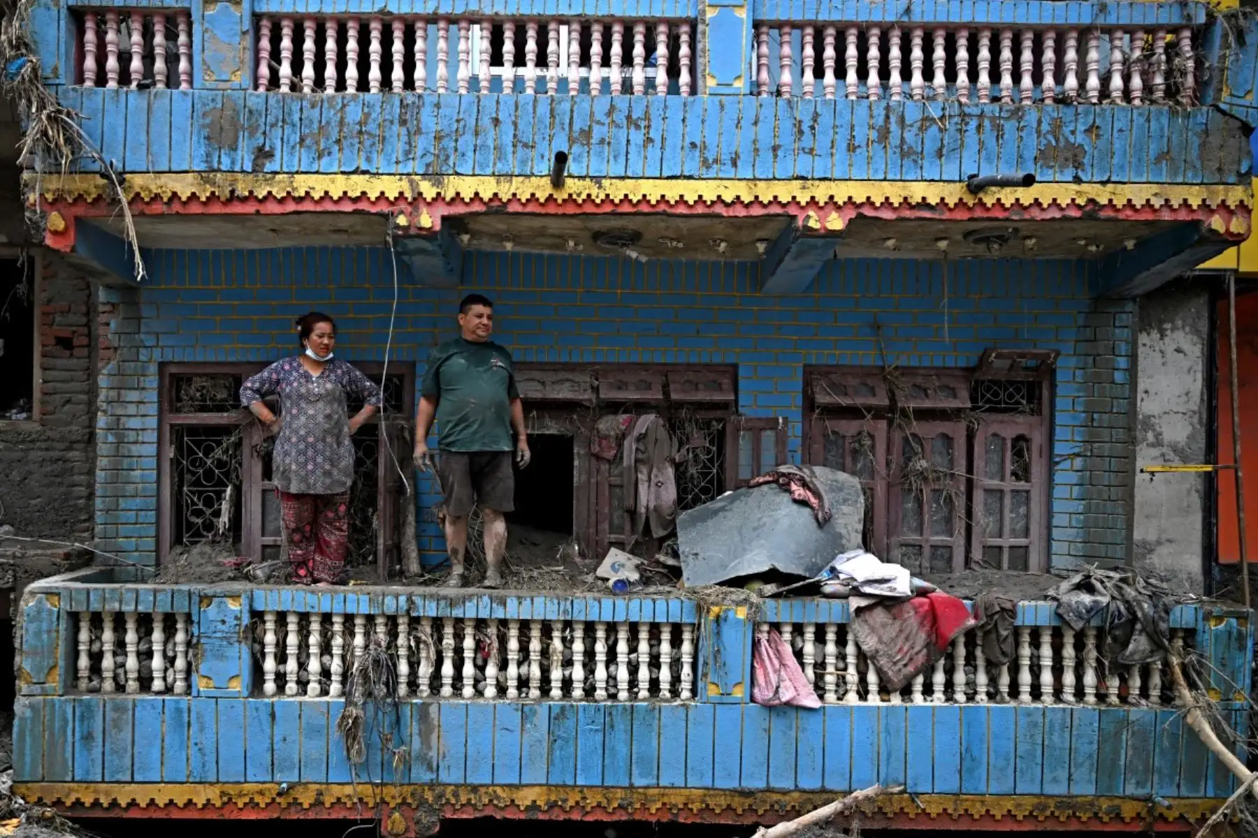 La gente observa mientras rescata pertenencias de sus hogares tras unas inundaciones repentinas en Devighat, en el distrito nepalí de Nuwakot. Foto: AFP
