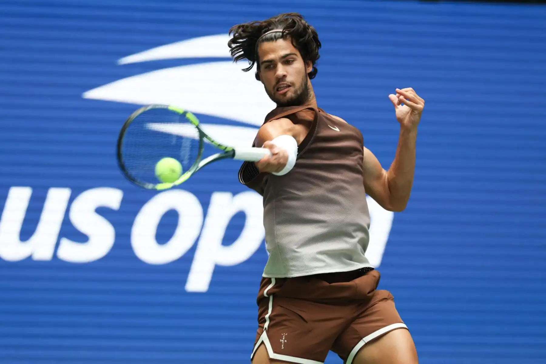 El español Carlos Alcaraz devuelve la pelota al ruso Roman Safiullin durante su partido de primera ronda del cuadro individual masculino, en la segunda jornada del torneo de tenis US Open, en el USTA Billie Jean King National Tennis Center de Nueva York. Foto: AFP
