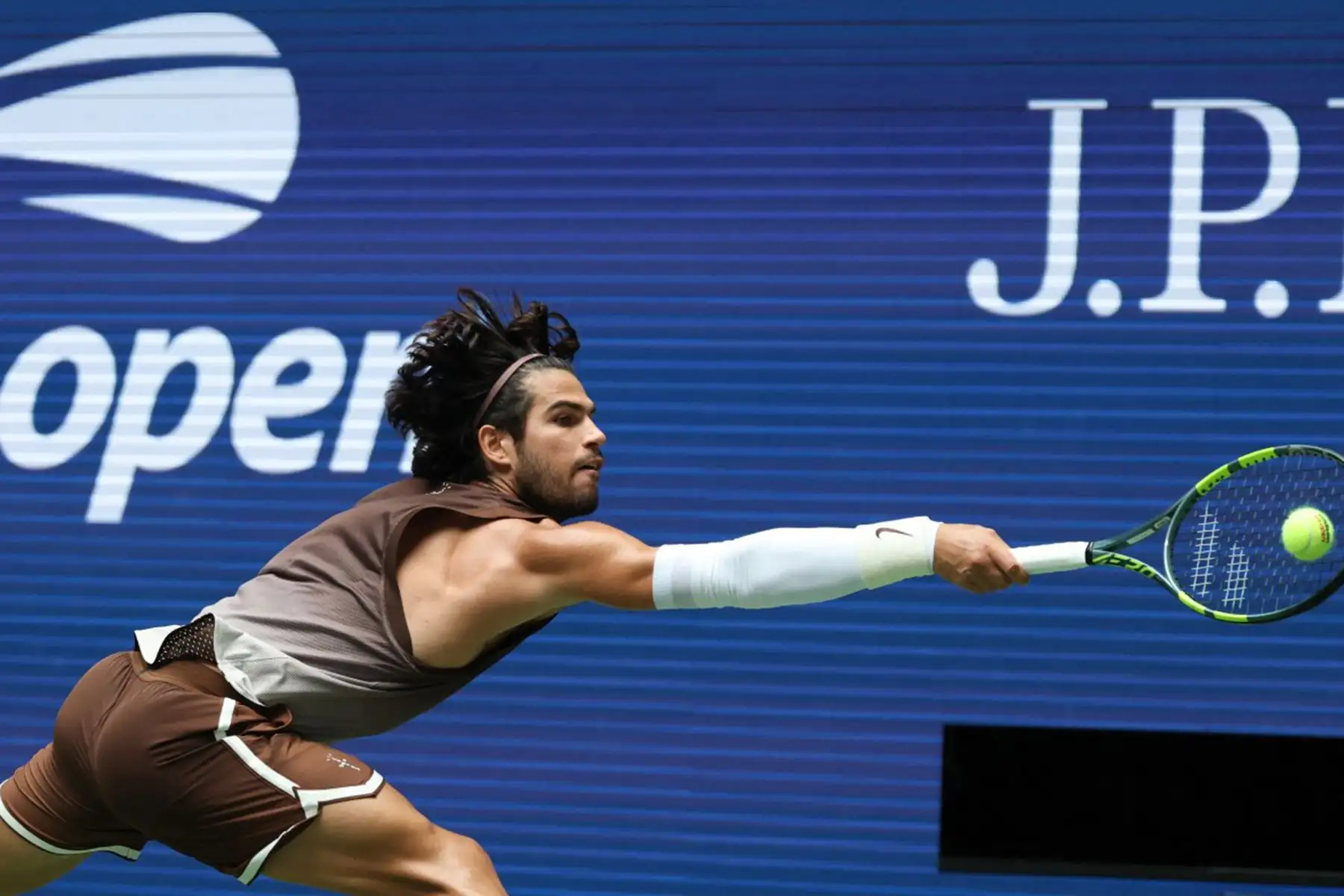 El español Carlos Alcaraz devuelve la pelota al ruso Roman Safiullin durante su partido de primera ronda del cuadro individual masculino, en la segunda jornada del torneo de tenis US Open, en el USTA Billie Jean King National Tennis Center de Nueva York. Foto: AFP