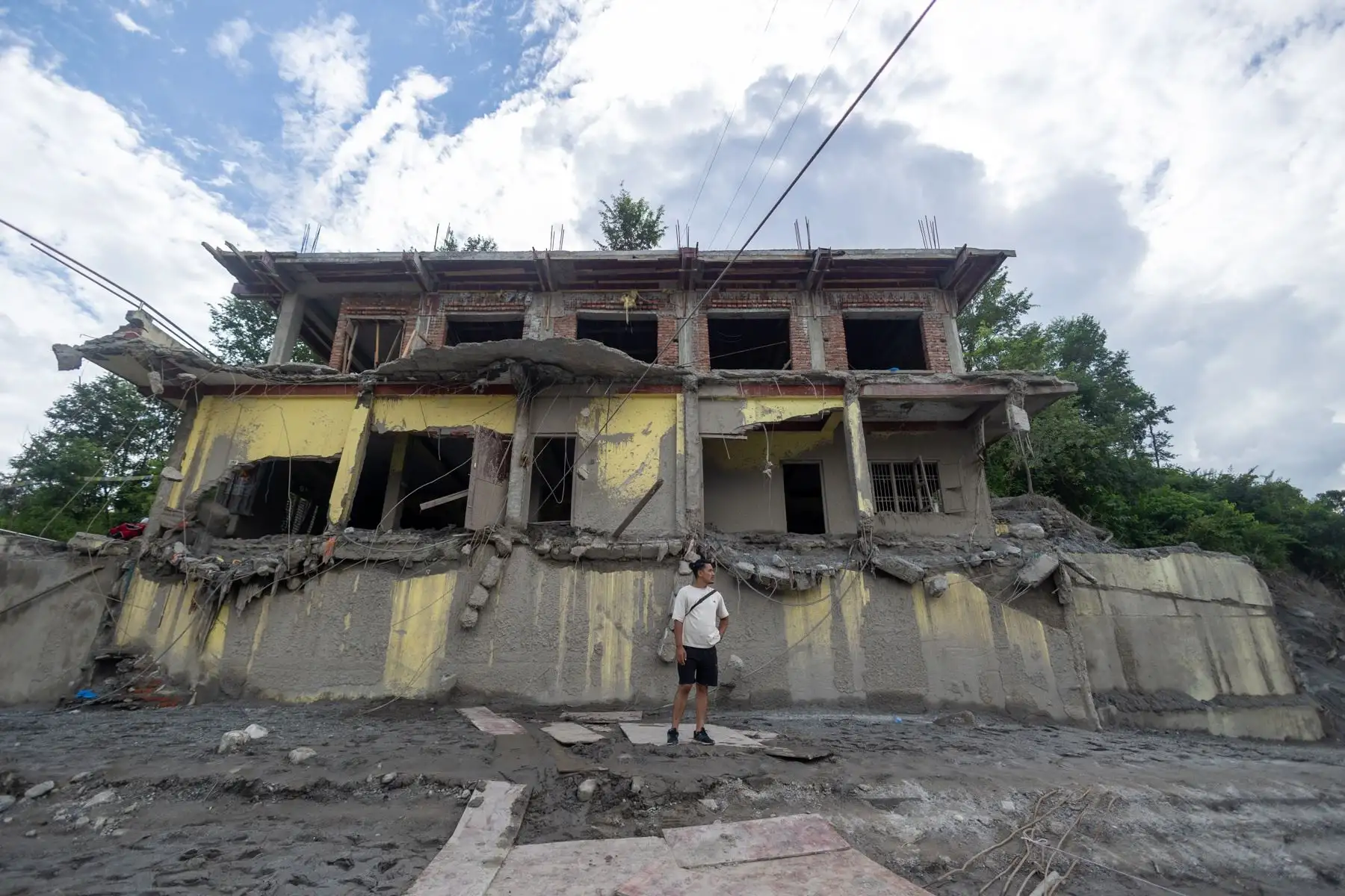 Un hombre cerca de un edificio afectado por una inundación de origen glaciar —que causó cientos de muertes— cerca de la frontera entre Nepal y China, en Trishuli Bazar, Nuwakot. Foto: EFE