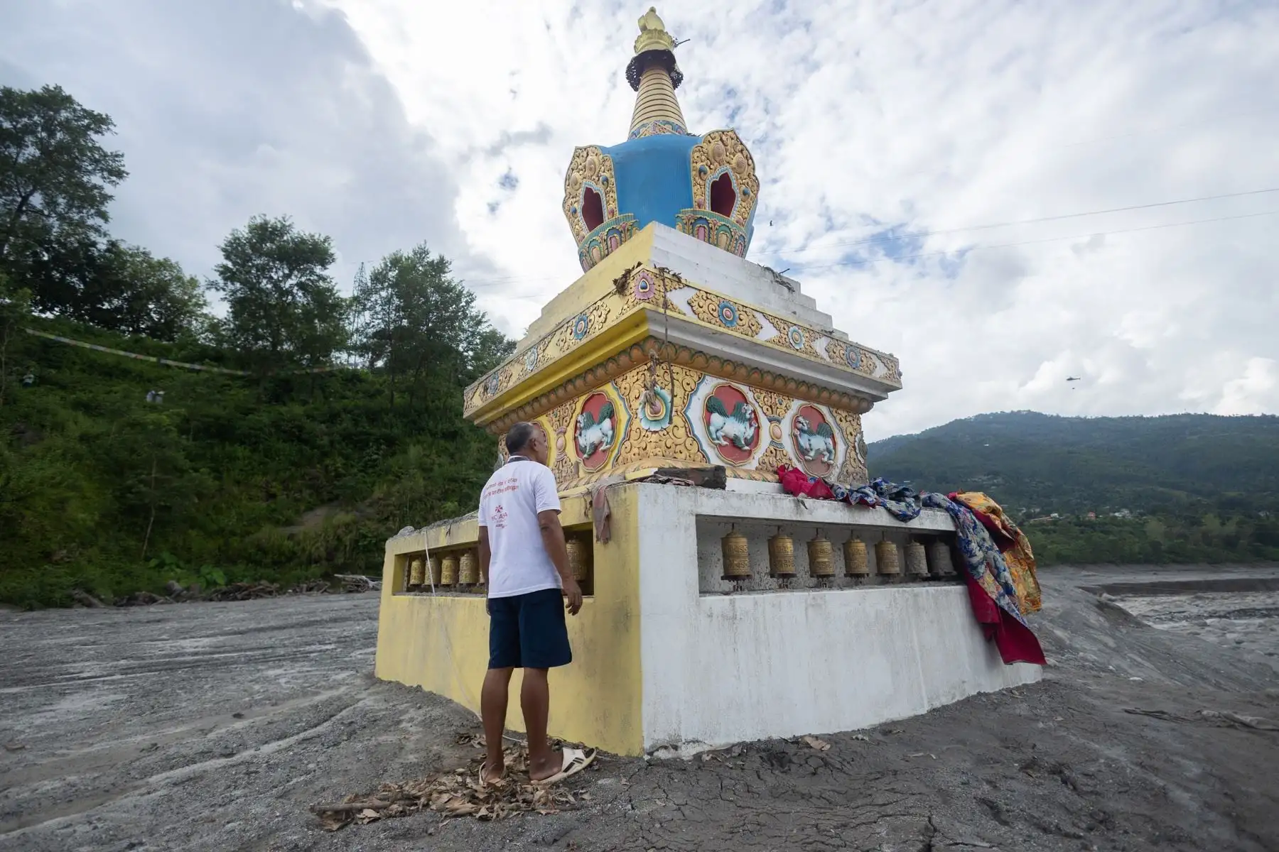 Un hombre limpia el monumento a Buda Gautama, afectado por una inundación de origen glaciar cerca de la frontera entre Nepal y China —suceso que causó cientos de víctimas mortales—, en Trishuli Bazar, Nuwakot (Nepal). Foto: EFE
