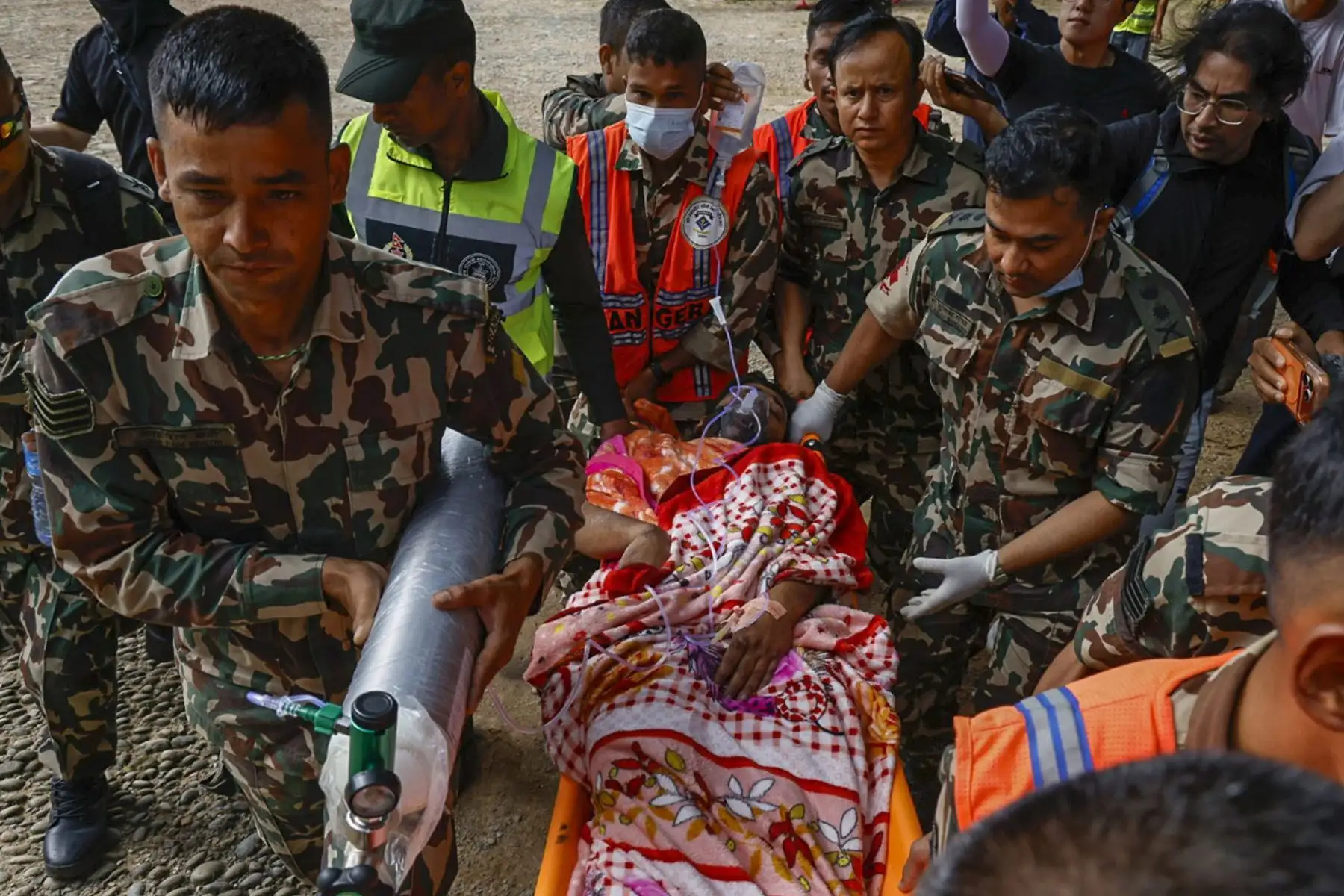 Un trabajador rescatado es llevado por personal militar tras permanecer atrapado bajo los escombros en un túnel del proyecto hidroeléctrico Trishuli-3A, en el distrito nepalí de Rasuwa. Foto: EFE