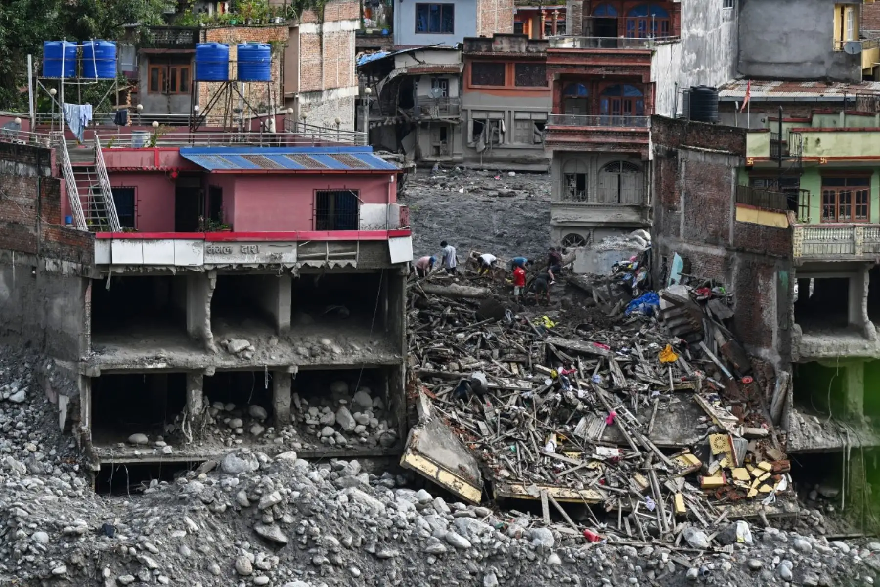 Supervivientes de una crecida repentina buscan pertenencias que puedan recuperarse en Trishuli Bazar, en el distrito nepalí de Nuwakot. Foto: AFP