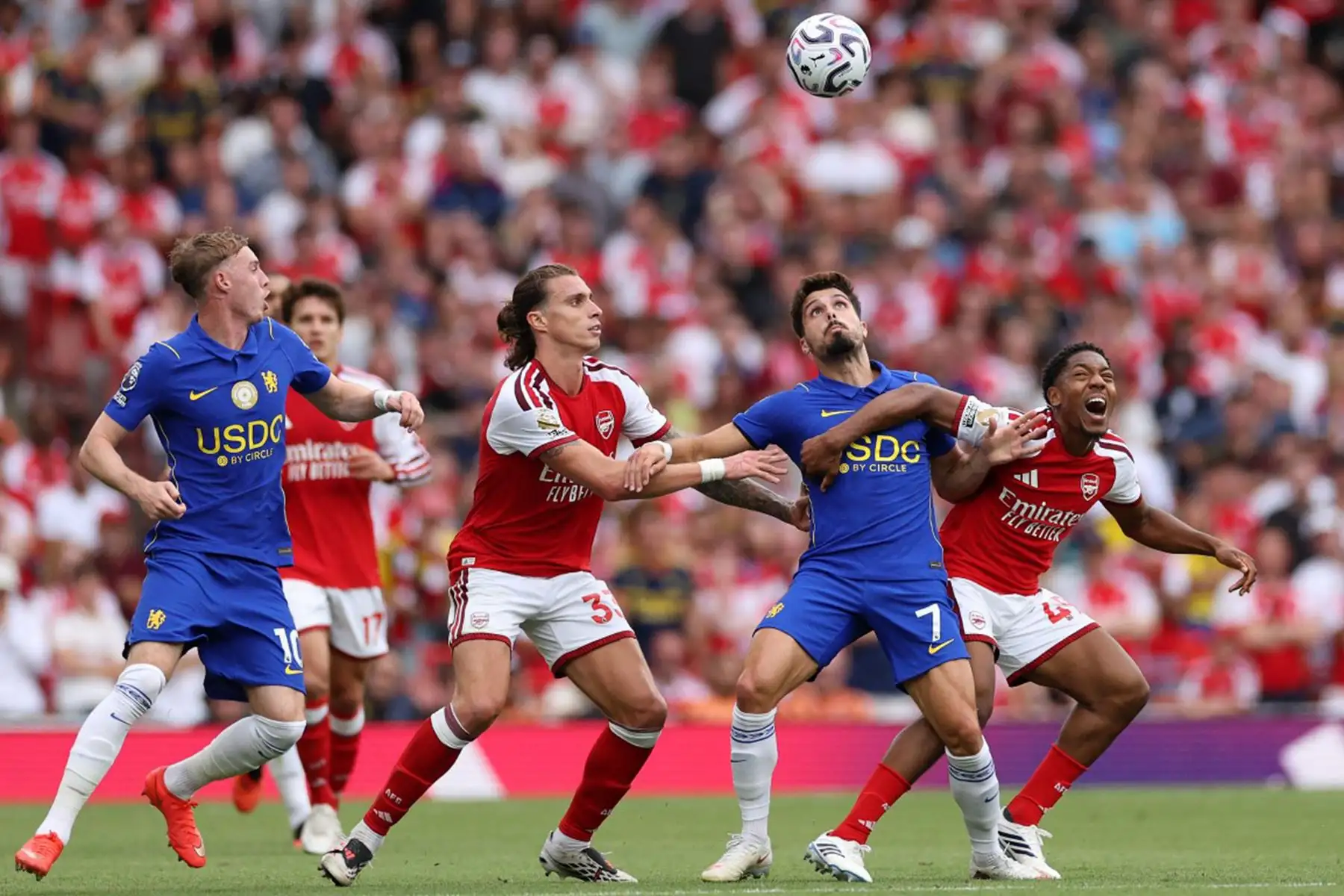 El centrocampista inglés del Arsenal, Myles Lewis-Skelly, disputa el balón con el centrocampista portugués del Chelsea, Pedro Neto y el defensa italiano del Arsenal, Riccardo Calafiori, mientras el centrocampista inglés del Chelsea, Cole Palmer, observa la acción durante el partido de la Premier League inglesa entre el Arsenal y el Chelsea en el Emirates Stadium de Londres. Foto: AFP