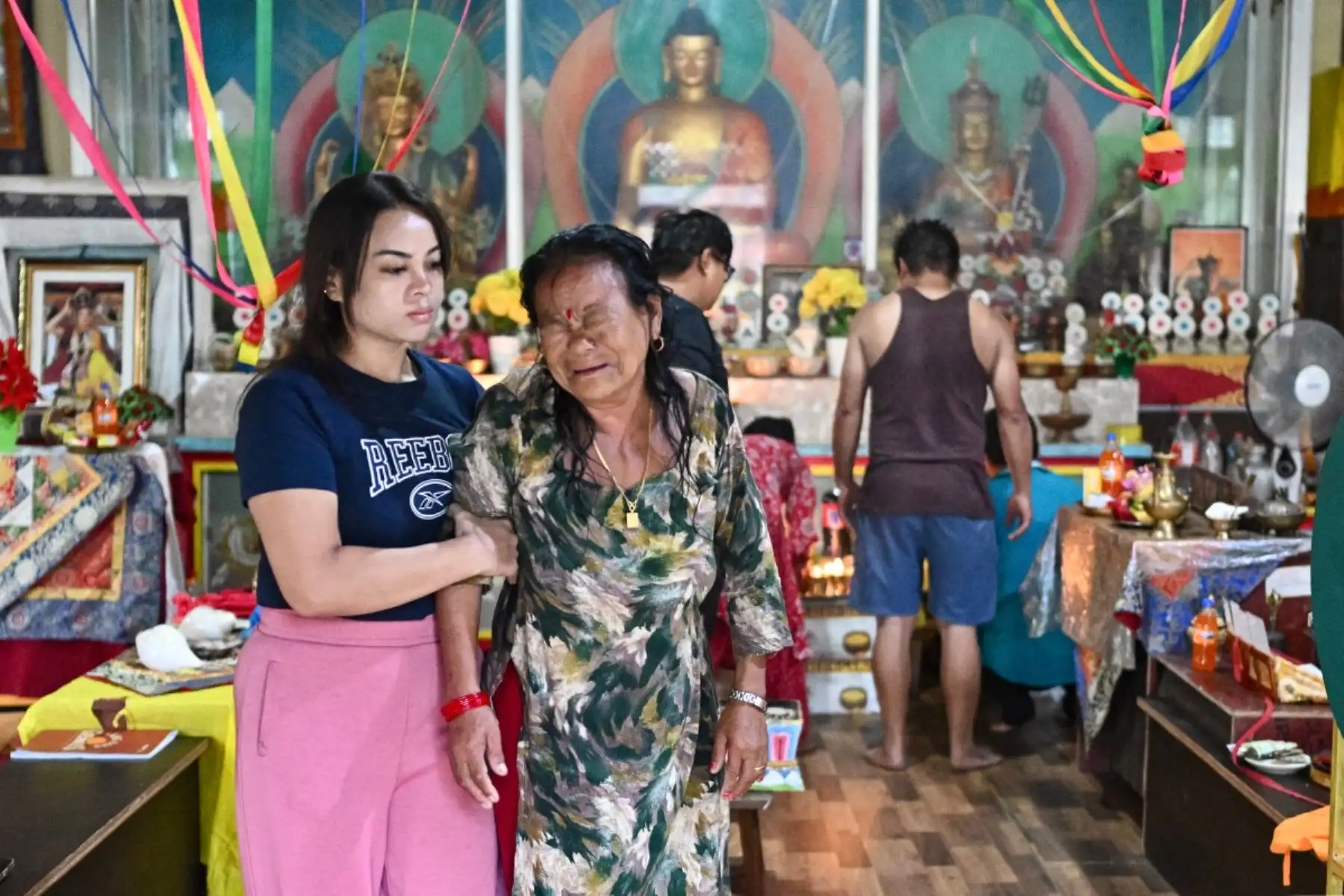 Los familiares de Hom Bahadur Tamang, desaparecido durante las inundaciones repentinas, expresan su pesar mientras participan en oraciones budistas en un templo de Trishuli, en el distrito nepalí de Nuwakot. Foto: AFP