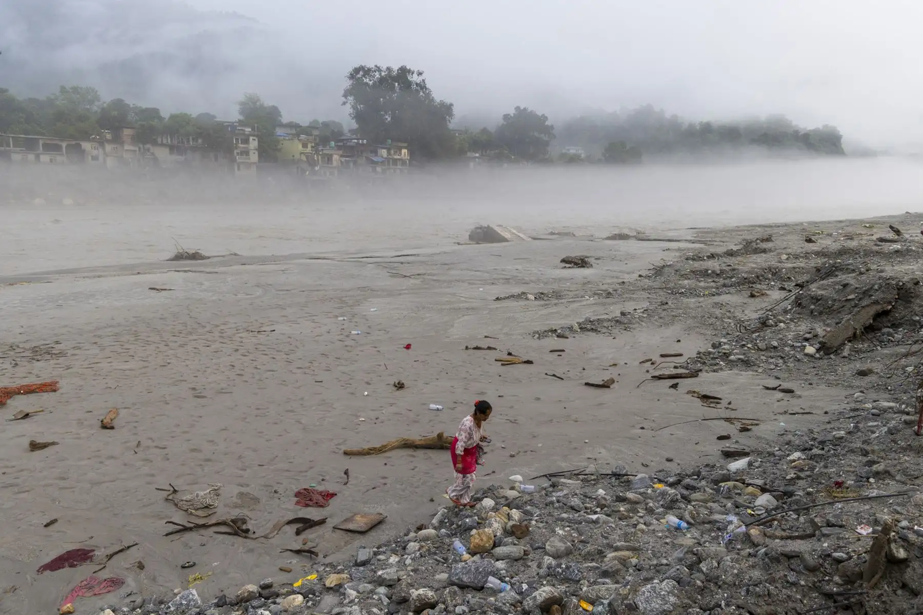 Una mujer camina por una zona afectada por las inundaciones en Devighat, distrito de Nuwakot (Nepal). Foto: EFE