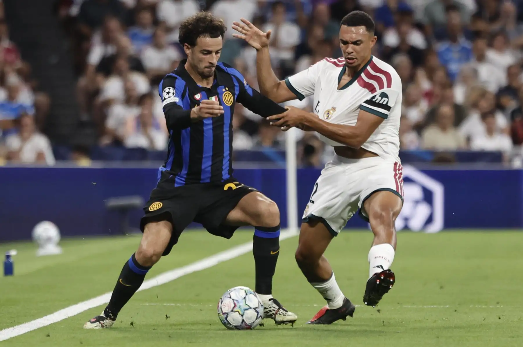 El defensa británico del Real Madrid, Trent Alexander-Arnold (d), disputa el balón ante el centrocampista del Inter de Milán, Nicolo Barella, durante el encuentro correspondiente a la Liga de Campeones que disputan Real Madrid e Inter de Milán, este martes en el estadio Santiago Bernabéu, en Madrid. Foto: EFE