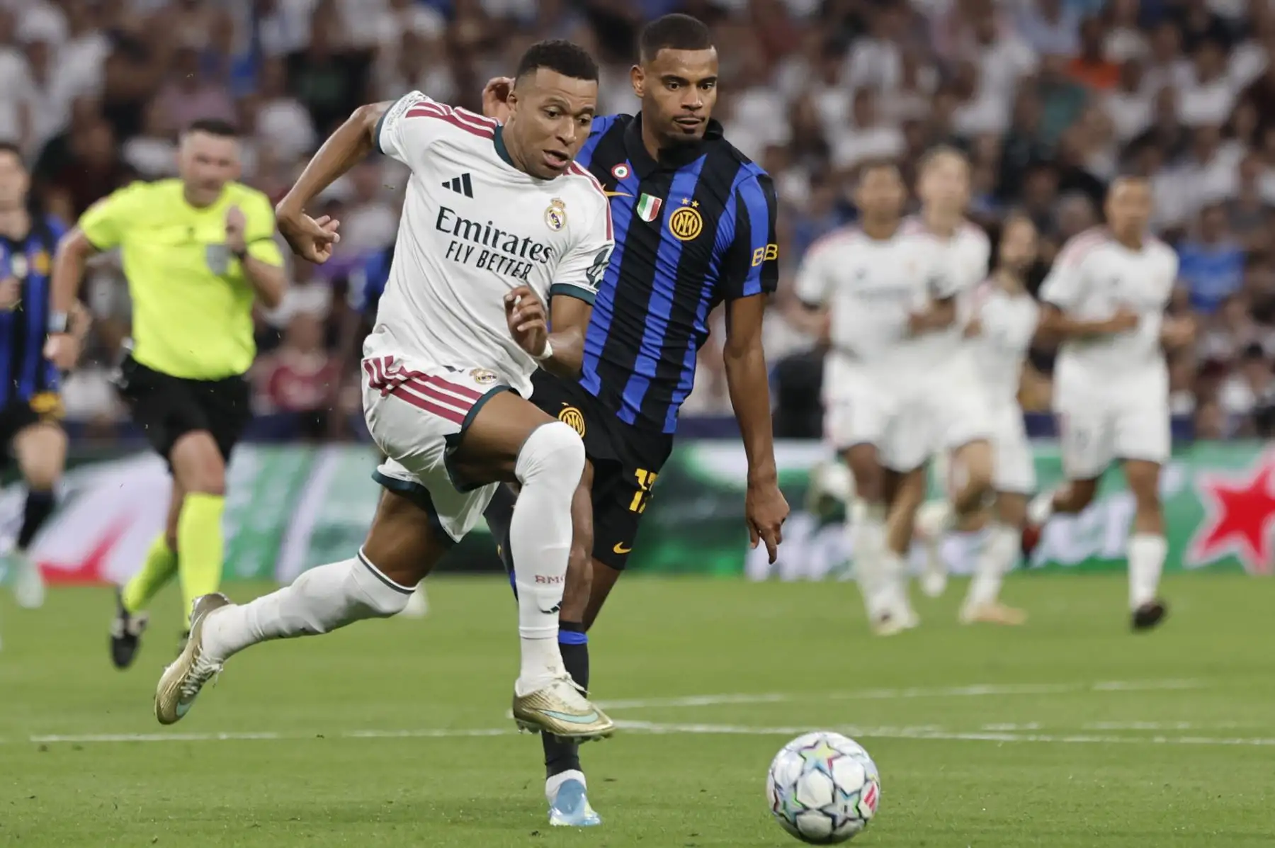 El delantero francés del Real Madrid, Kylian Mbappé (i) lucha con Andy Diouf, del Inter, durante el encuentro correspondiente a la Liga de Campeones que disputan Real Madrid e Inter de Milán, este martes en el estadio Santiago Bernabéu, en Madrid. Foto: EFE