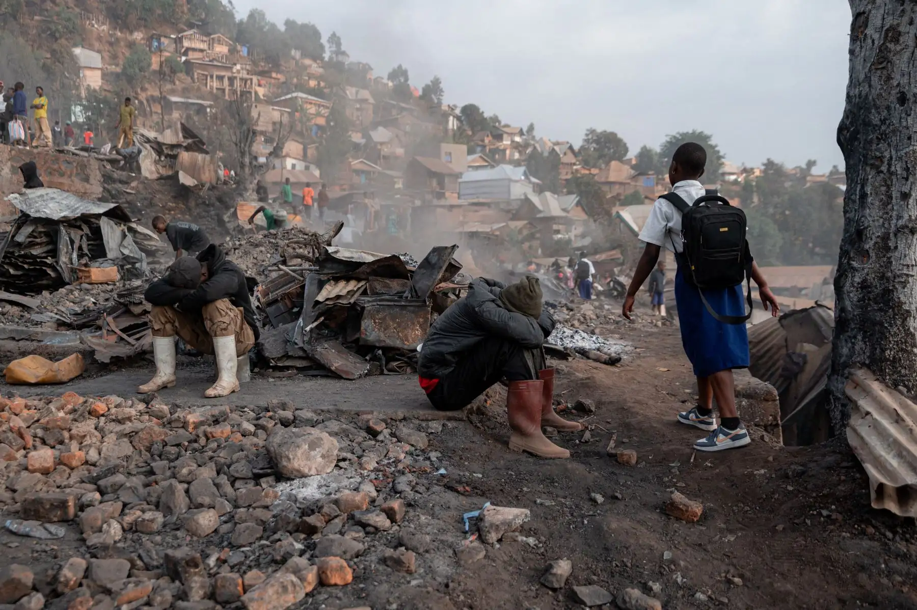 Escolares pasan junto a casas quemadas camino a su escuela, un día después de un incendio mortal en RD Congo, el 11 de septiembre de 2026. Foto: AFP