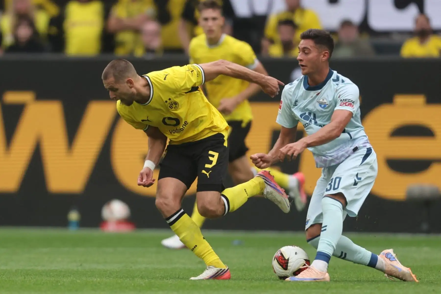 El defensa alemán del Dortmund, Waldemar Anton (n.º 3), y el delantero alemán del Paderborn, Stefano Marino (n.º 30), pugnan por el balón durante el partido de la Bundesliga (primera división alemana) entre el Borussia Dortmund y el SC Paderborn, disputado en Dortmund el 12 de septiembre de 2026.
Foto: AFP