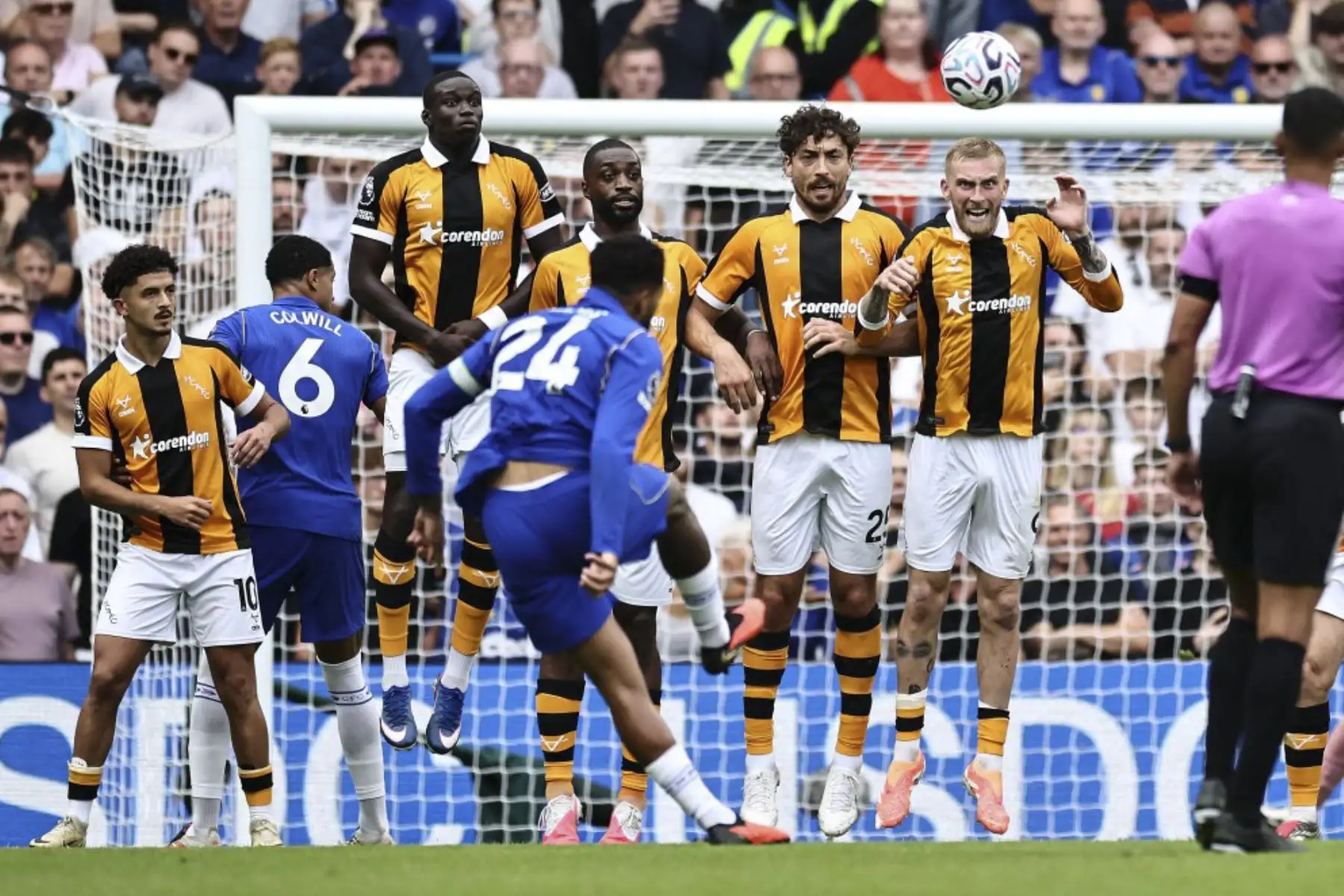 El delantero escocés del Hull City, Oli McBurnie (n.º 9, centro), salta en la barrera para despejar el tiro libre del defensa inglés del Chelsea, Reece James (n.º 24), durante el partido de la Premier League inglesa entre el Chelsea y el Hull City en Stamford Bridge, Londres, el 12 de septiembre de 2026.
Foto: AFP