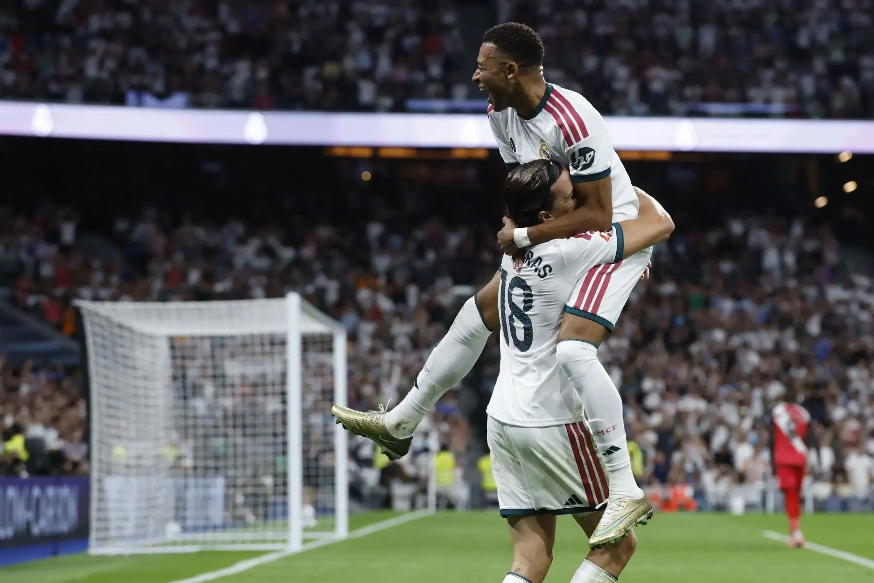 El defensa español del Real Madrid, Álvaro Fernández Carreras, celebra con el delantero francés Kylian Mbappé tras marcar el segundo gol de su equipo durante el partido de la liga española de fútbol entre el Real Madrid CF y el Rayo Vallecano de Madrid en el estadio Santiago Bernabéu, el 12 de septiembre de 2026. Foto: AFP