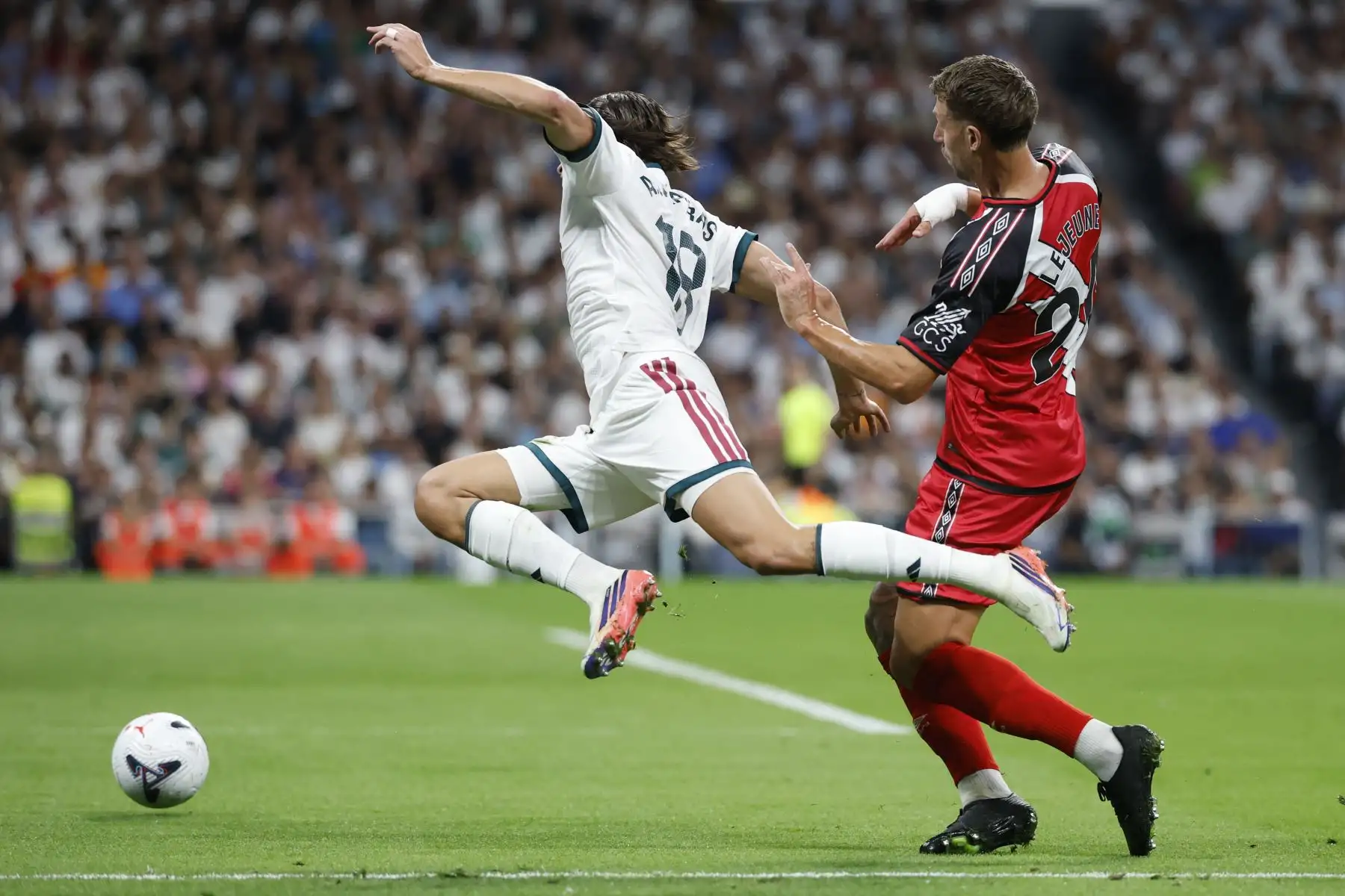 El defensa español del Real Madrid, Álvaro Fernández Carreras, recibe una falta del defensa francés del Rayo Vallecano, Florian Lejeune, durante el partido de la liga española de fútbol entre el Real Madrid CF y el Rayo Vallecano de Madrid en el estadio Santiago Bernabéu el 12 de septiembre de 2026. Foto: AFP