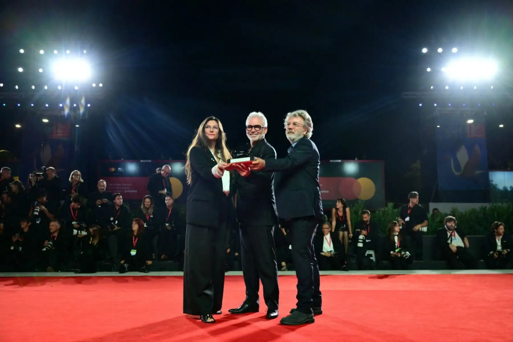 Los directores de cine francés Stéphane Brizé, Coralie Amedeo y Olivier Gorce, ganadores del premio al mejor guion en Venecia por "Un bon petit soldat" (Un buen soldado), posan en la alfombra roja tras la ceremonia de clausura de la 83.ª edición del Festival de Cine de Venecia. Foto: AFP