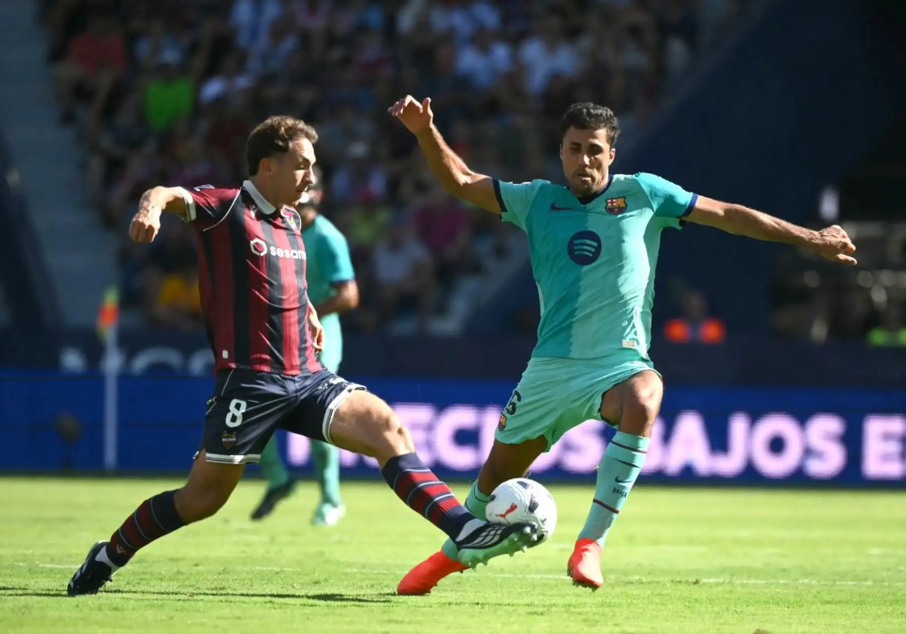 El centrocampista español del Barcelona n.º 16, Rodrigo, lucha por el balón con el centrocampista español del Levante n.º 8, Jon Ander Olasagasti, durante el partido de la liga española de fútbol entre el Levante UD y el FC Barcelona en el estadio Ciutat de València, en Valencia, el 13 de septiembre de 2026.
 Foto: AFP