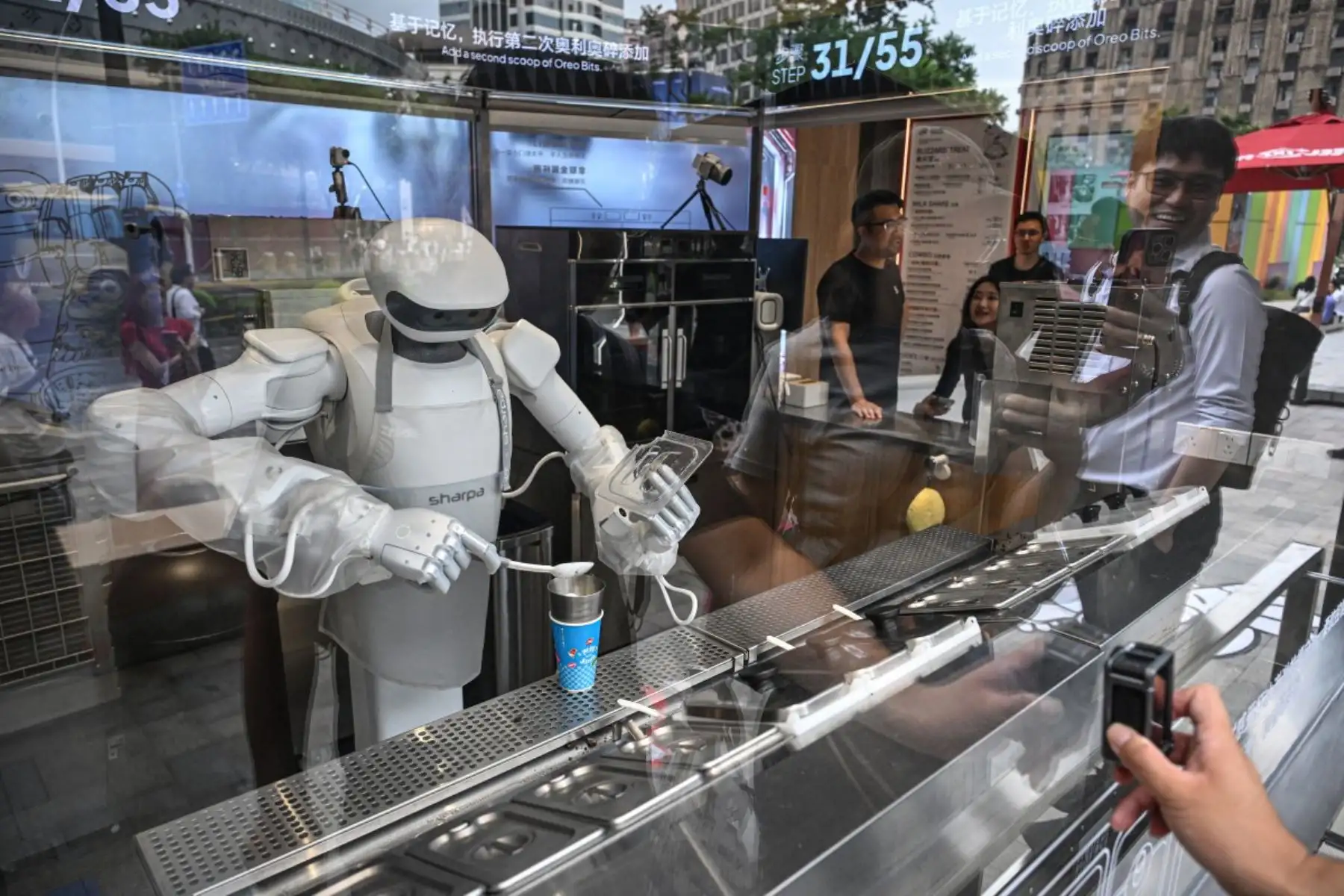 Un robot Sharpa prepara un helado Blizzard para un cliente en una tienda Dairy Queen en Shanghái. (Foto de Jade GAO / AFP)