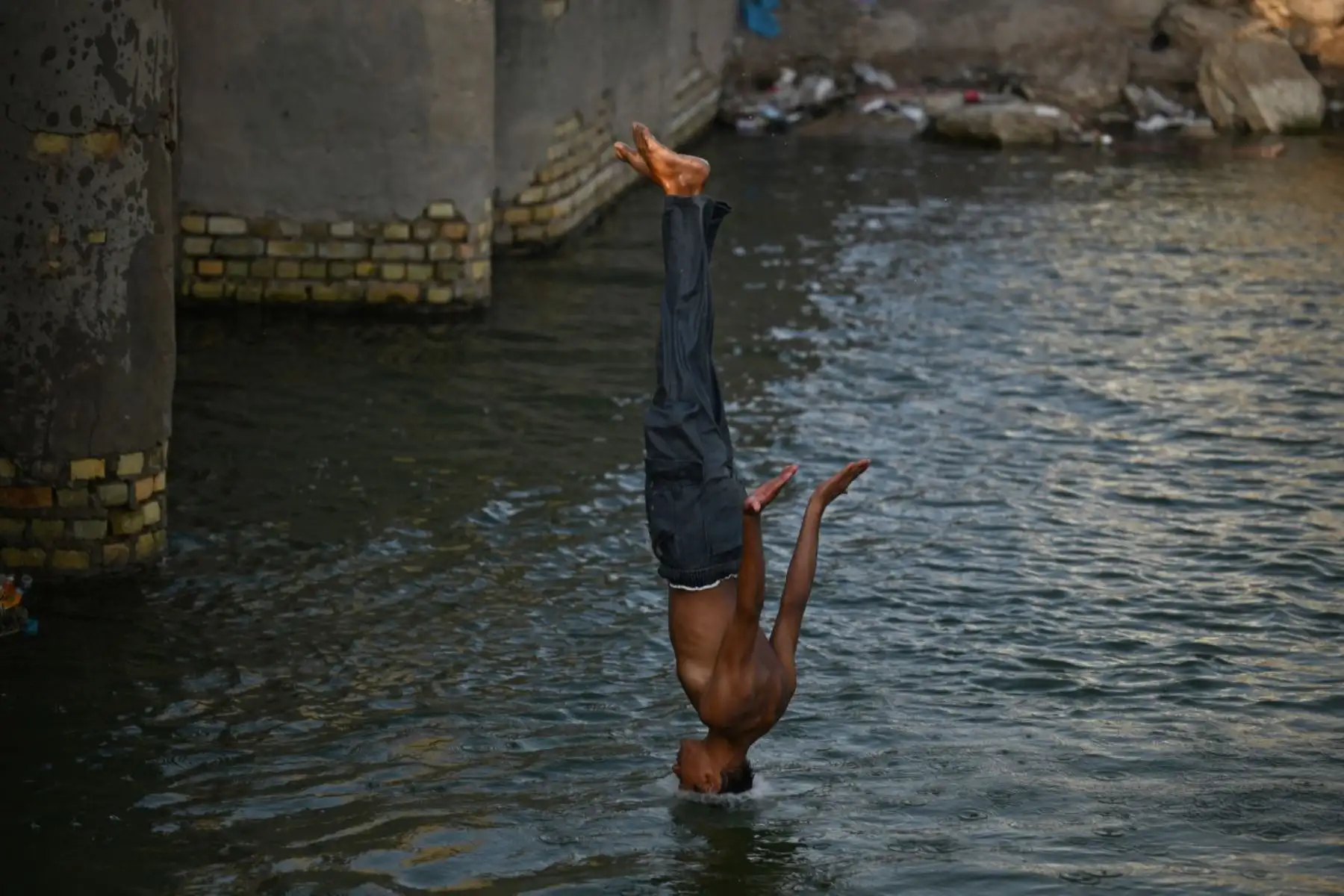 Un joven iraquí se zambulle en el río Shatt al-Arab en Basora en medio de temperaturas extremas. (Foto de Hussein FALEH / AFP)