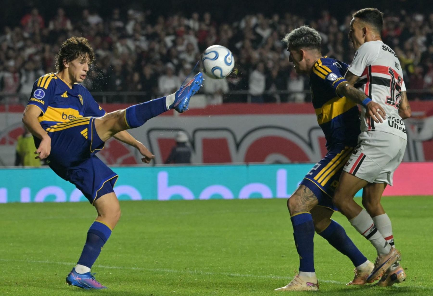El defensa de Boca Juniors Facundo Herrera golpea el balón, superando a su compañero y defensa Lautaro Di Lollo  y al defensa del São Paulo Iago Borduchi, durante el partido de vuelta de los cuartos de final de la Copa Sudamericana entre el São Paulo de Brasil y Boca Juniors de Argentina, en el estadio Morumbi de São Paulo, Brasil. Foto: AFP