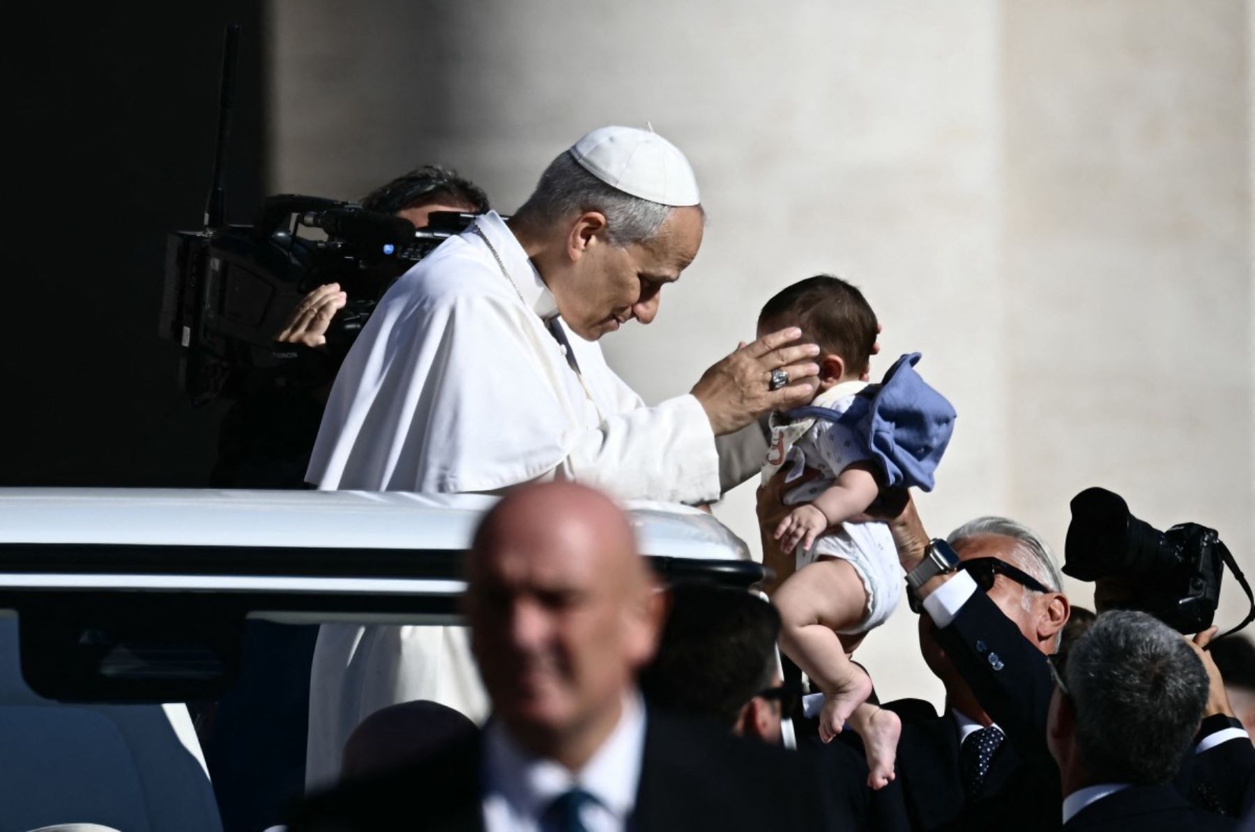 El papa León XIV bendice a un niño pequeño a su llegada para presidir la audiencia general semanal en el Vaticano. Foto: AFP