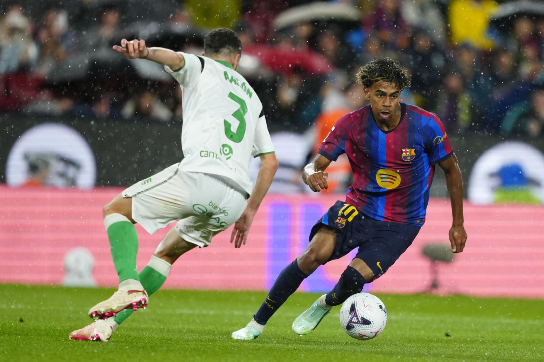 El delantero del FC Barcelona Lamine Yamal (d) se escapa de Aarón Martín, del Racing, en el partido de la sexta jornada de LaLiga que FC Barcelona y Racing de Santander disputan hoy miércoles en el Camp Nou. Foto: EFE