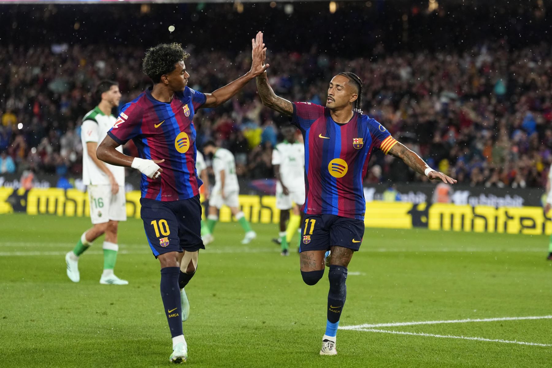 El delantero del Barcelona Raphinha (d) celebra con Lamine Yamal tras marcar el 2-0, durante el partido de la sexta jornada de LaLiga que FC Barcelona y Racing de Santander disputan hoy miércoles en el Camp Nou. Foto: EFE