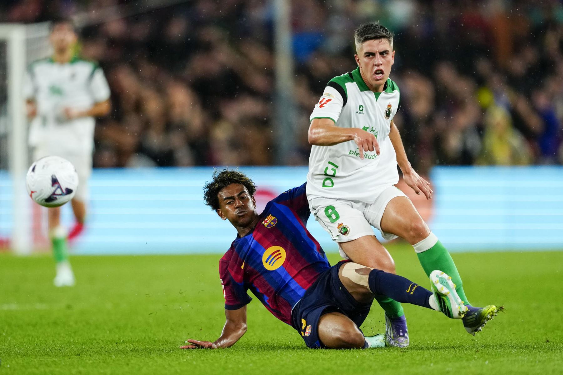 El delantero del FC Barcelona Lamine Yamal (i) lucha con Íñigo Sainz, del Racing, en el partido de la sexta jornada de LaLiga que FC Barcelona y Racing de Santander disputan hoy miércoles en el Camp Nou. Foto: EFE
