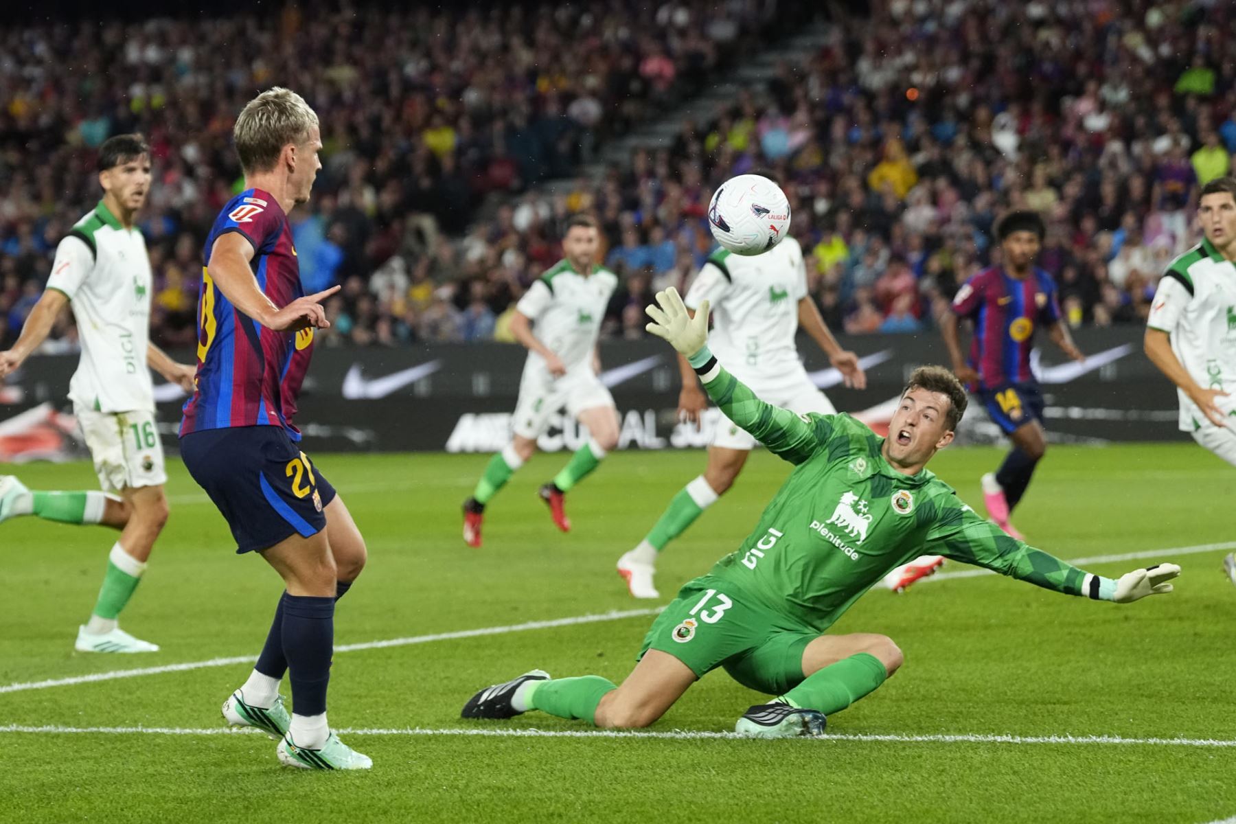 El centrocampista del FC Barcelona Dani Olmo (i) dispara a puerta ante Julen Agirrezabala, guardameta del Racing, en el partido de la sexta jornada de LaLiga que FC Barcelona y Racing de Santander disputan hoy miércoles en el Camp Nou.  Foto: EFE
