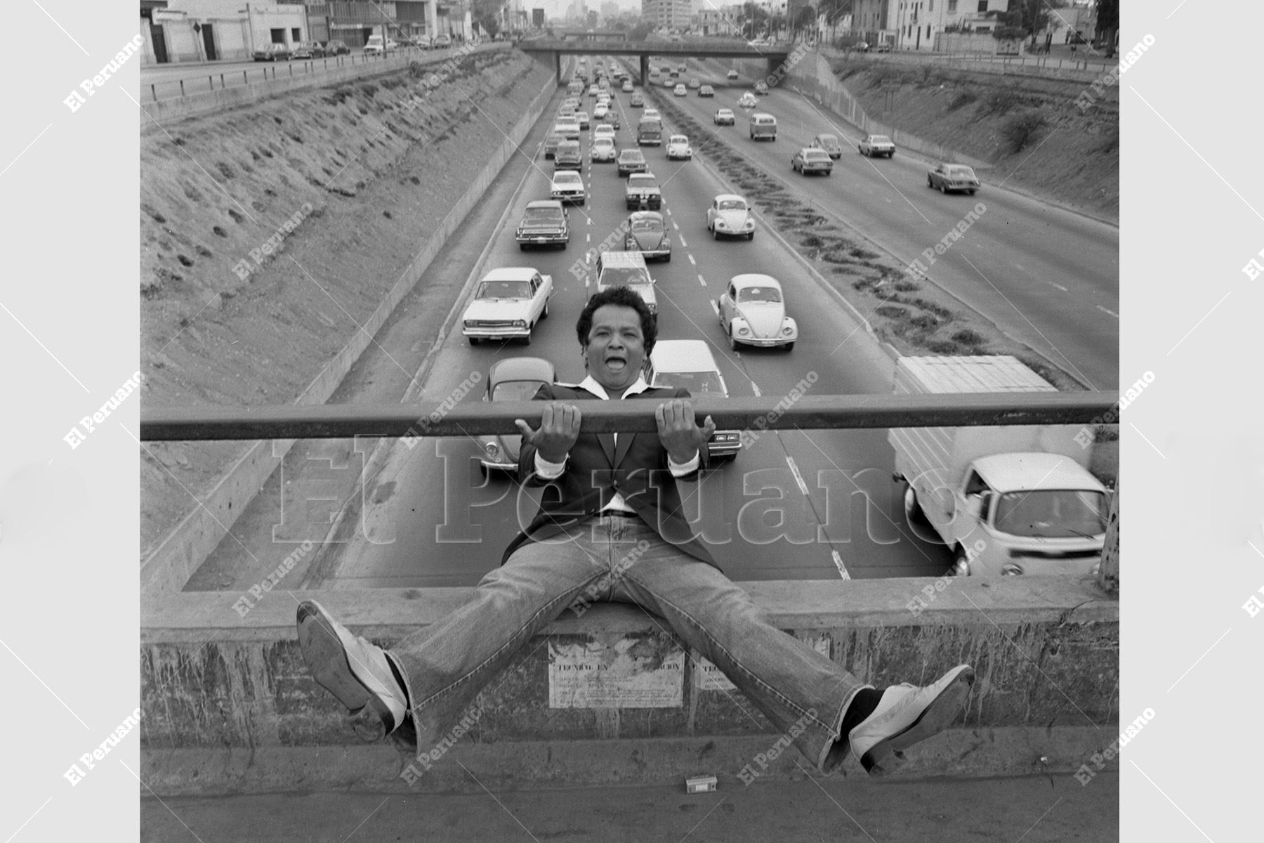 Lima - 26 julio 1983 / Haciendo gala de su picardía, Pablo Villanueva "Melcochita" se divierte en las barandas de la Vía Expresa. Un retrato que captura la esencia espontánea del comediante y sonero. Foto: Archivo Histórico de El Peruano / Rómulo Luján