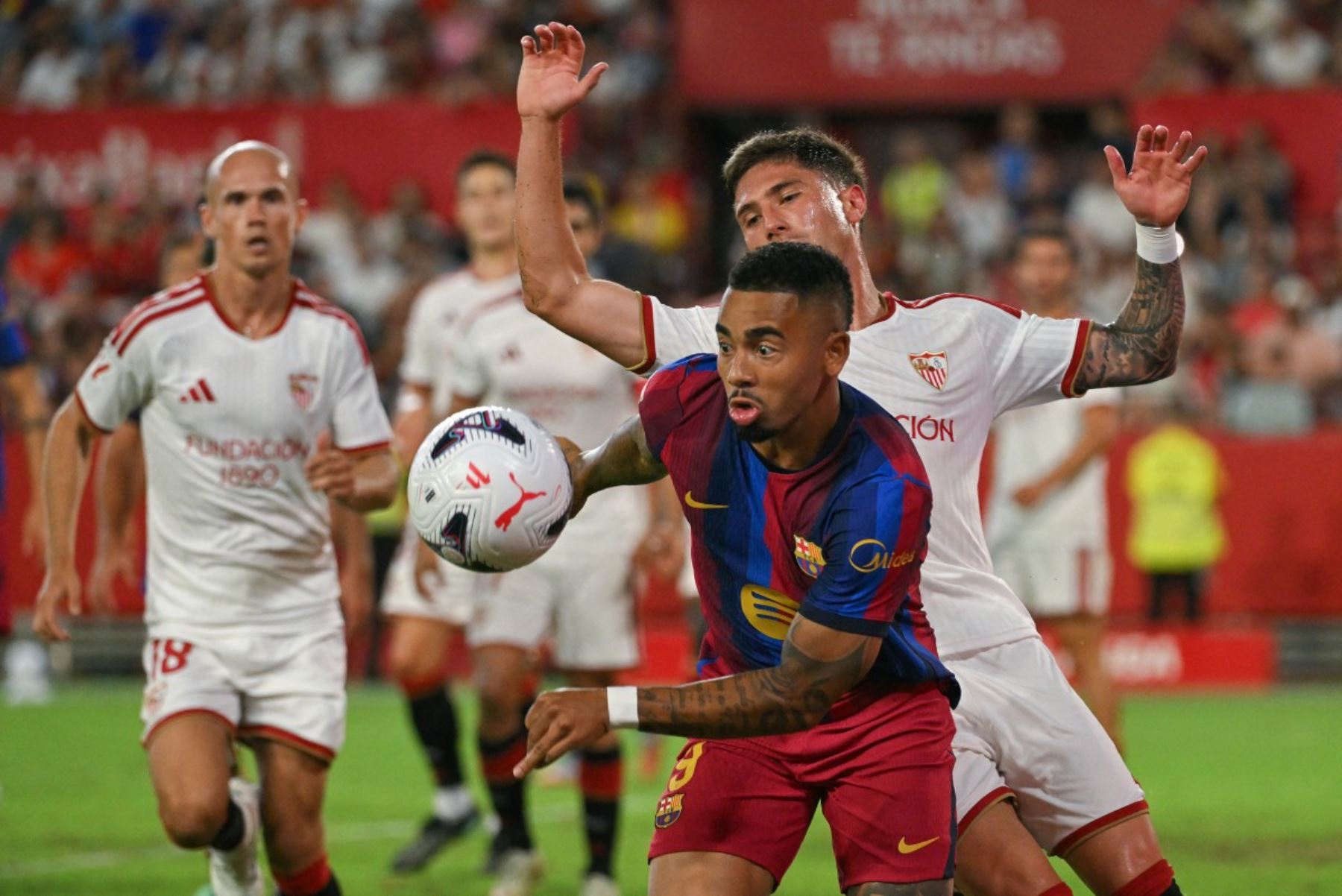 El delantero brasileño del Barcelona, ​​Gabriel Jesus (izq.), y el defensa español del Sevilla, José Ángel Carmona, disputó el balón durante el partido de la liga española entre el Sevilla FC y el FC Barcelona en el estadio Ramón Sánchez Pizjuán de Sevilla, el 19 de septiembre de 2026. (Foto de Jorge Guerrero / AFP)