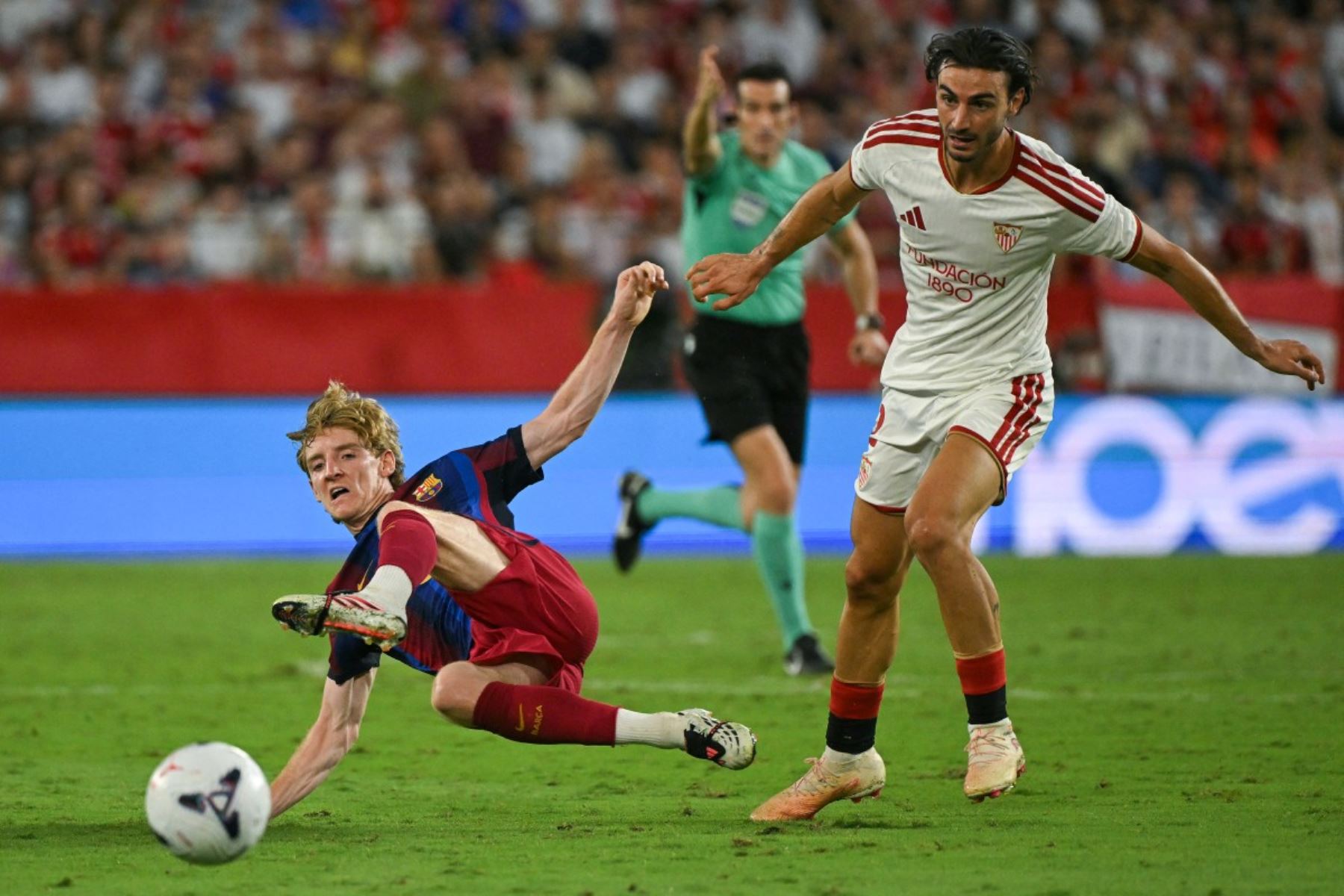El delantero inglés del Barcelona, ​​Anthony Gordon (izq.), y el defensa español del Sevilla, Juan Iglesias, luchan por el balón durante el partido de la liga española entre el Sevilla FC y el FC Barcelona en el estadio Ramón Sánchez Pizjuán de Sevilla, el 19 de septiembre de 2026. (Foto de Jorge Guerrero / AFP)