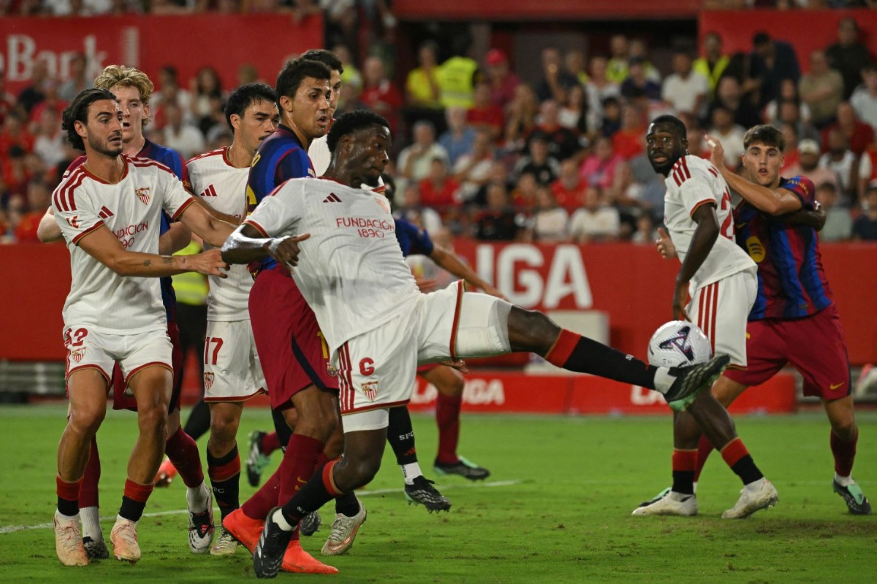 El centrocampista francés del Sevilla, Lucien Agoume (número 6), patea el balón durante el partido de la liga española entre el Sevilla FC y el FC Barcelona en el estadio Ramón Sánchez Pizjuán de Sevilla, el 19 de septiembre de 2026. (Foto de JORGE GUERRERO / AFP)