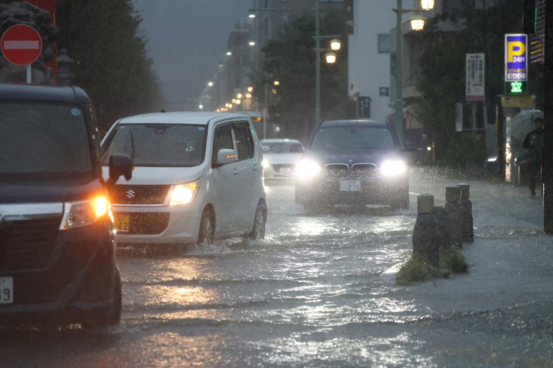 Vehículos circulan por una calle inundada durante las fuertes lluvias provocadas por la llegada del tifón Dujuan en la ciudad de Kamakura, prefectura de Kanagawa, Japón, el 21 de septiembre de 2026. Foto: AFP