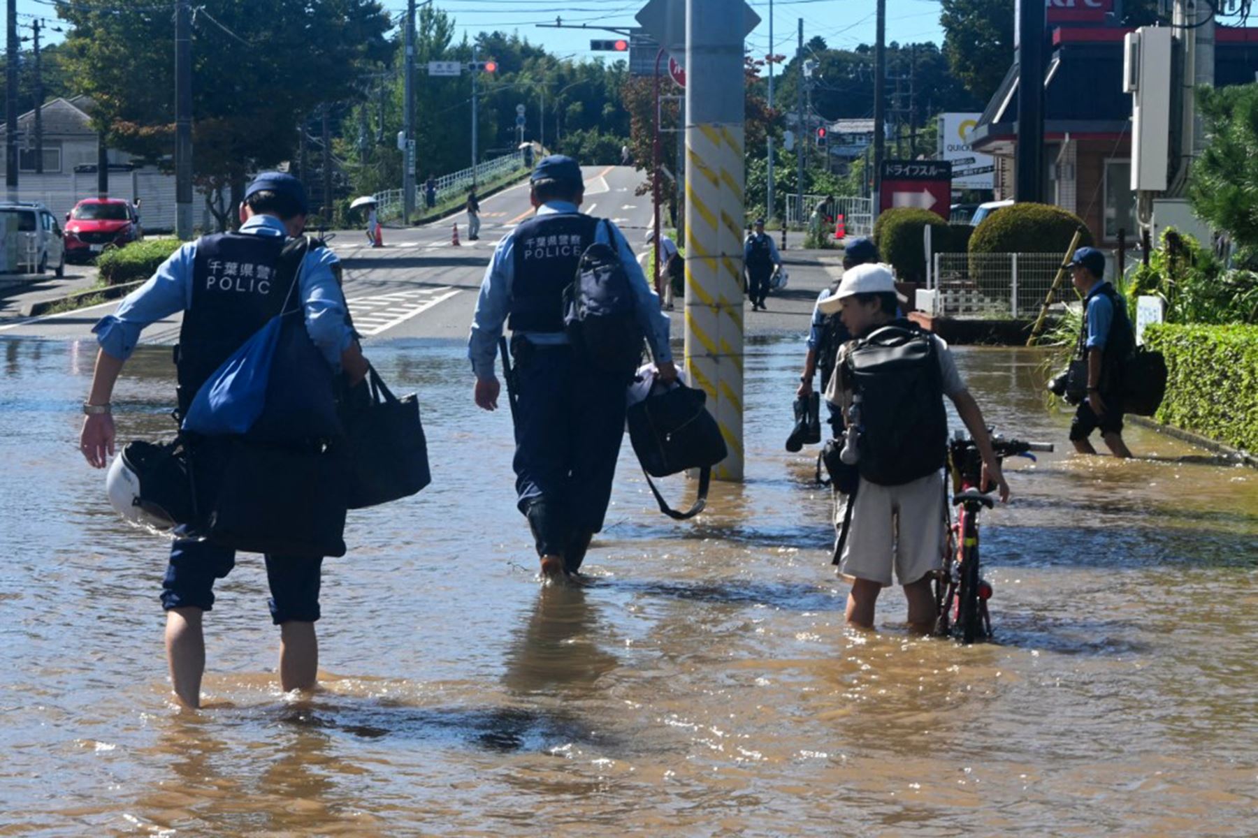 Agentes de policía salieron de la comisaría de Sakura y atravesaron una calle inundada para patrullar la ciudad de Sakura, en la prefectura de Chiba (Japón). Foto: AFP