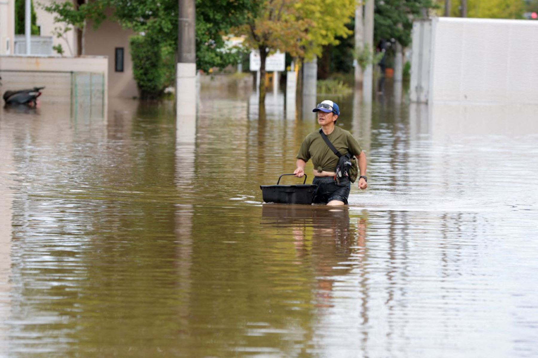 Un hombre camina por una calle residencial inundada tras las fuertes lluvias provocadas por la aproximación del tifón Dujuan en la ciudad de Sakura, prefectura de Chiba (este de Japón). Foto: AFP