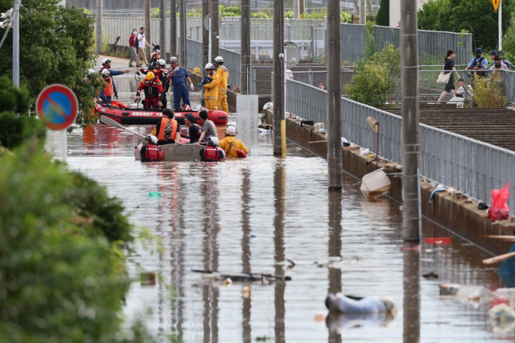 Bomberos rescatan a personas de una casa aislada en barco a lo largo de una calle inundada después de las fuertes lluvias provocadas por el tifón Dujuan que se acercaba en la ciudad de Sakura, prefectura de Chiba, al este de Japón. Foto: AFP