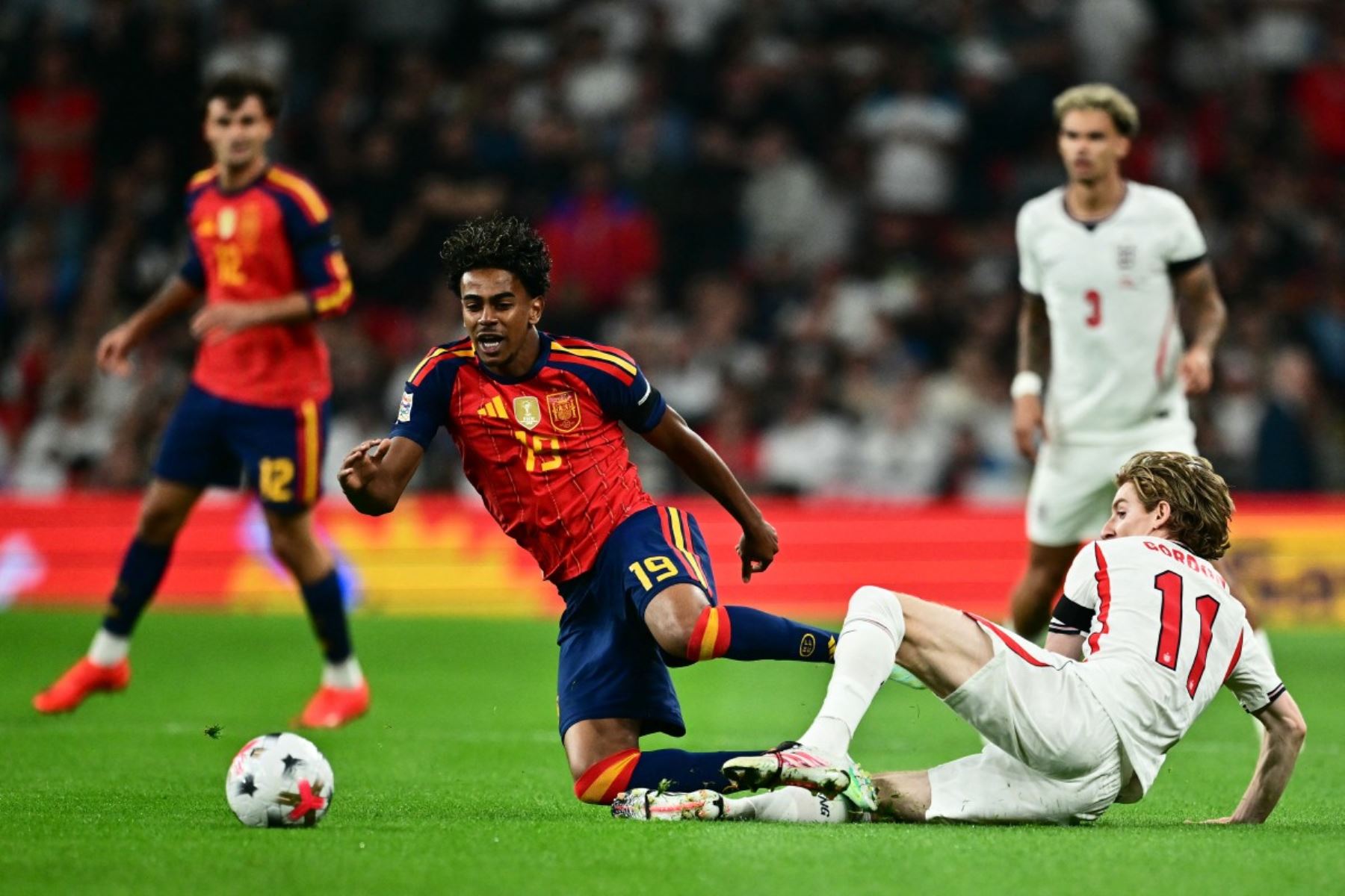 El delantero español Lamine Yamal (izq.), número 19, disputa el balón con el centrocampista inglés Anthony Gordon (der.), número 11, durante el partido de la Liga de Naciones de la UEFA, Liga A - Grupo 3, entre Inglaterra y España en el estadio de Wembley en Londres, el 26 de septiembre de 2026. Foto: AFP
