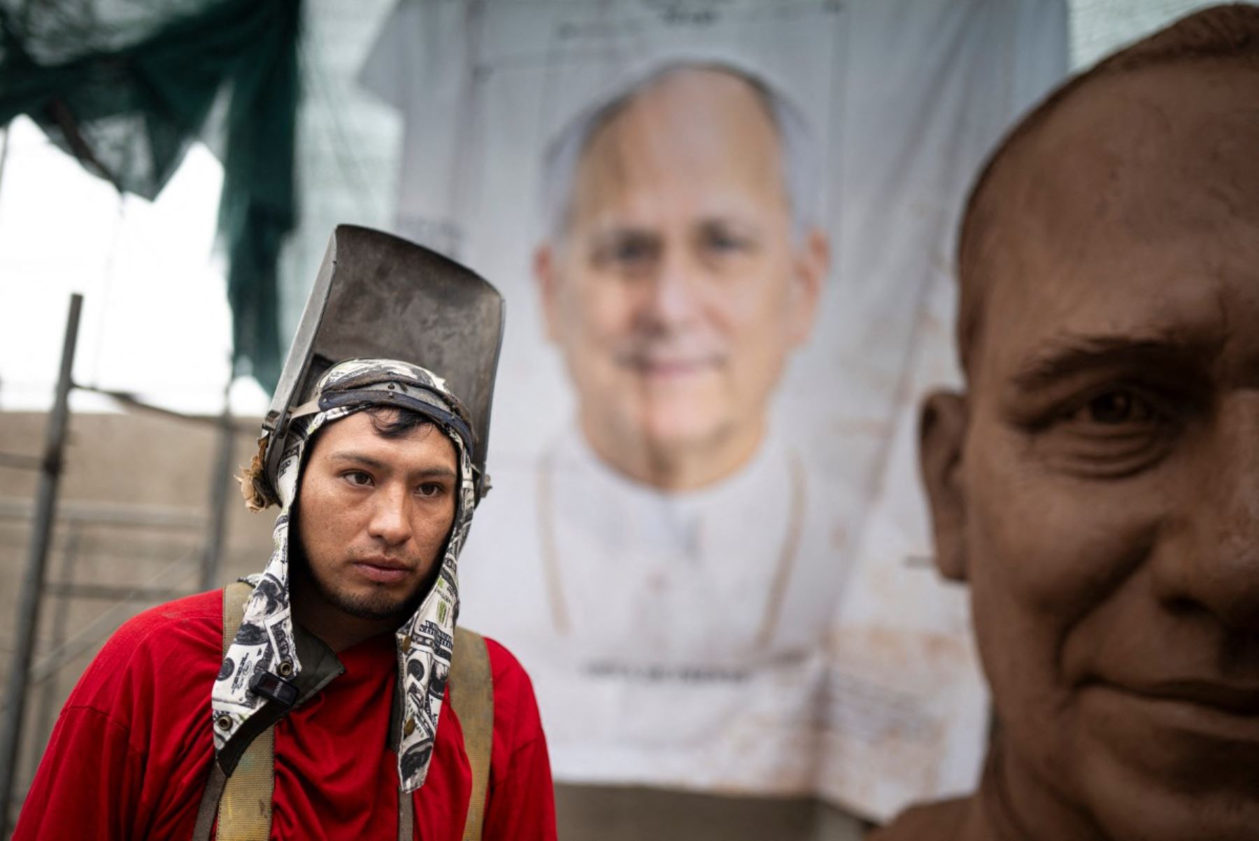 Un trabajador pasa junto a la cabeza de una escultura del papa León XIV en un taller en el distrito de Carabayllo, en las afueras del norte de Lima, el 25 de septiembre de 2026. Foto: AFP
