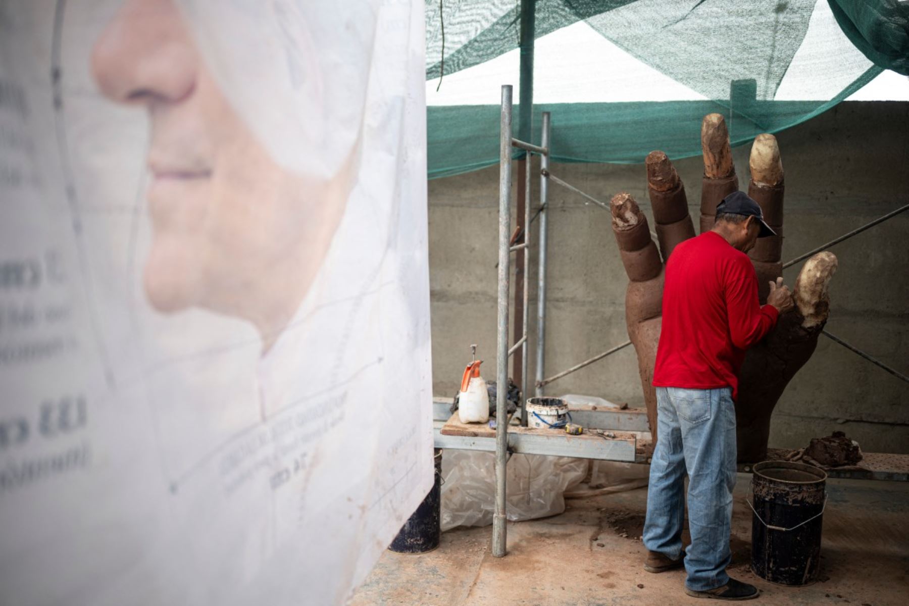 Un artesano trabaja en la mano de una escultura del papa León XIV durante su elaboración en un taller en el distrito de Carabayllo, en las afueras norte de Lima. Foto: AFP