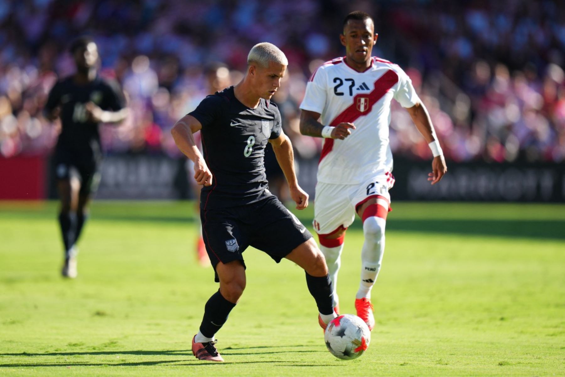 Cavan Sullivan #8 de Estados Unidos controla el balón bajo la presión de Marcos López #4 de Perú durante el partido amistoso internacional entre Estados Unidos y Perú en el Estadio Inter.co el 26 de septiembre de 2026 en Orlando, Florida. Foto: AFP